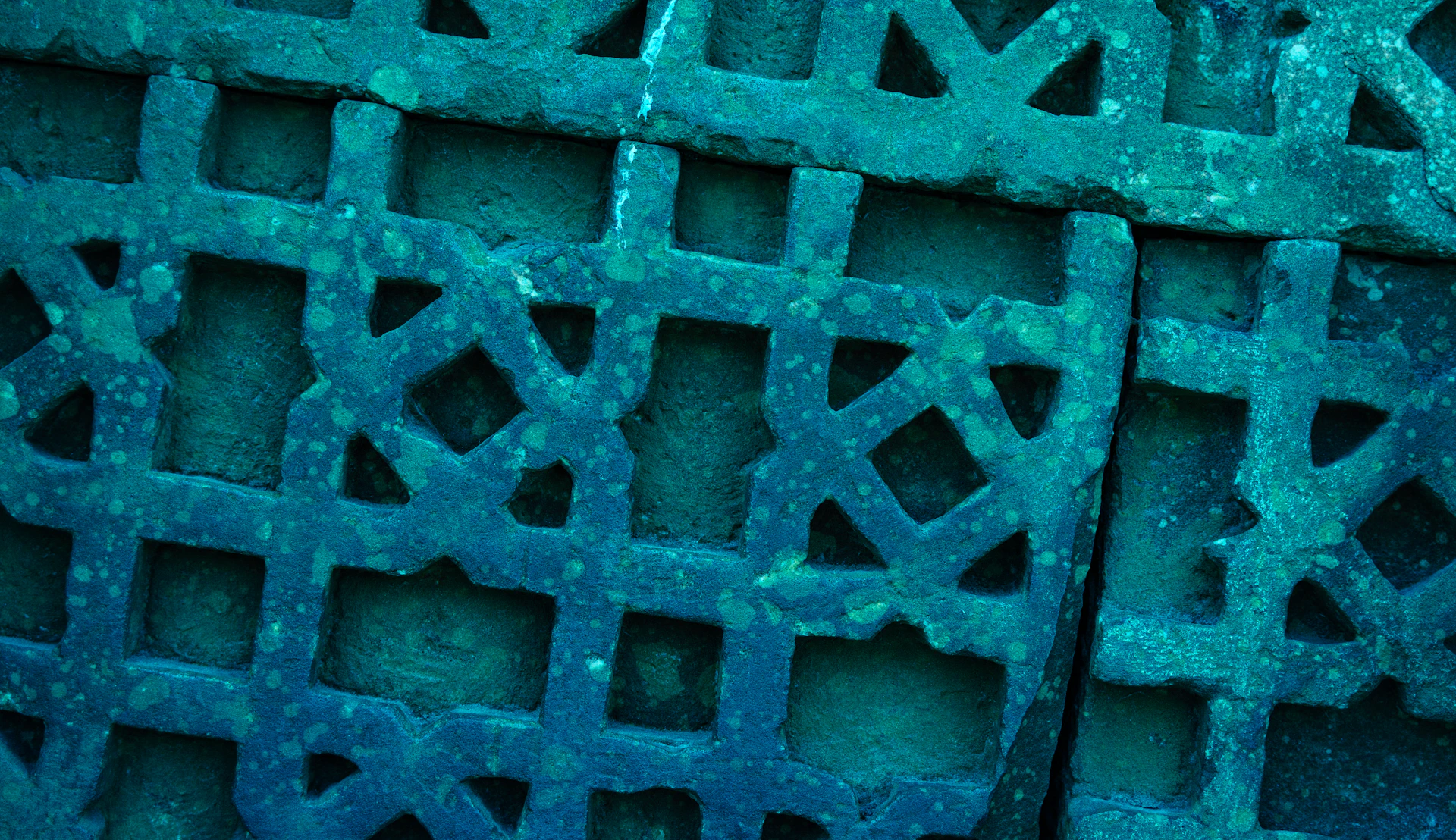 Close-up of a teal-colored decorative metal grate