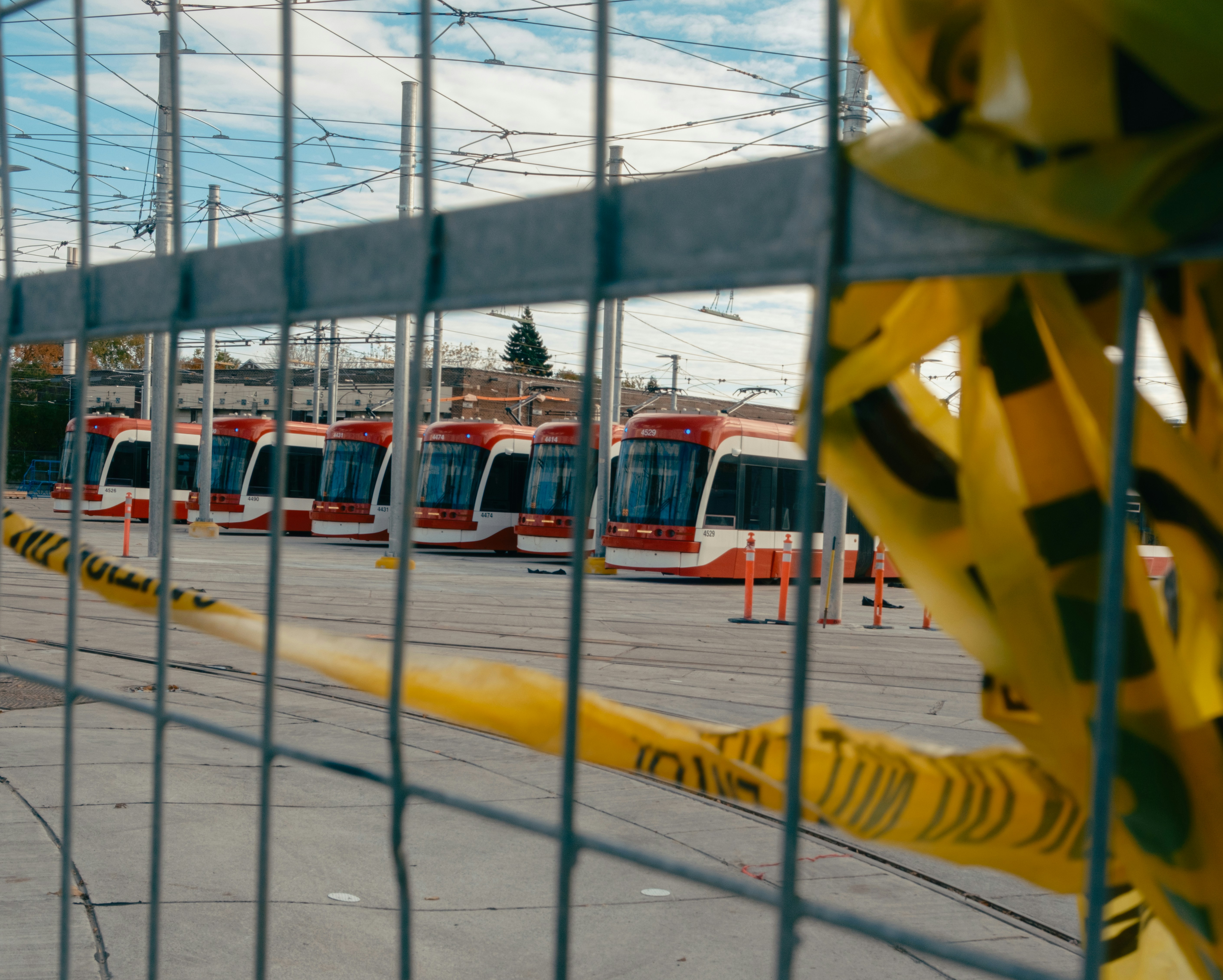 Red and white trams parked in a lot.