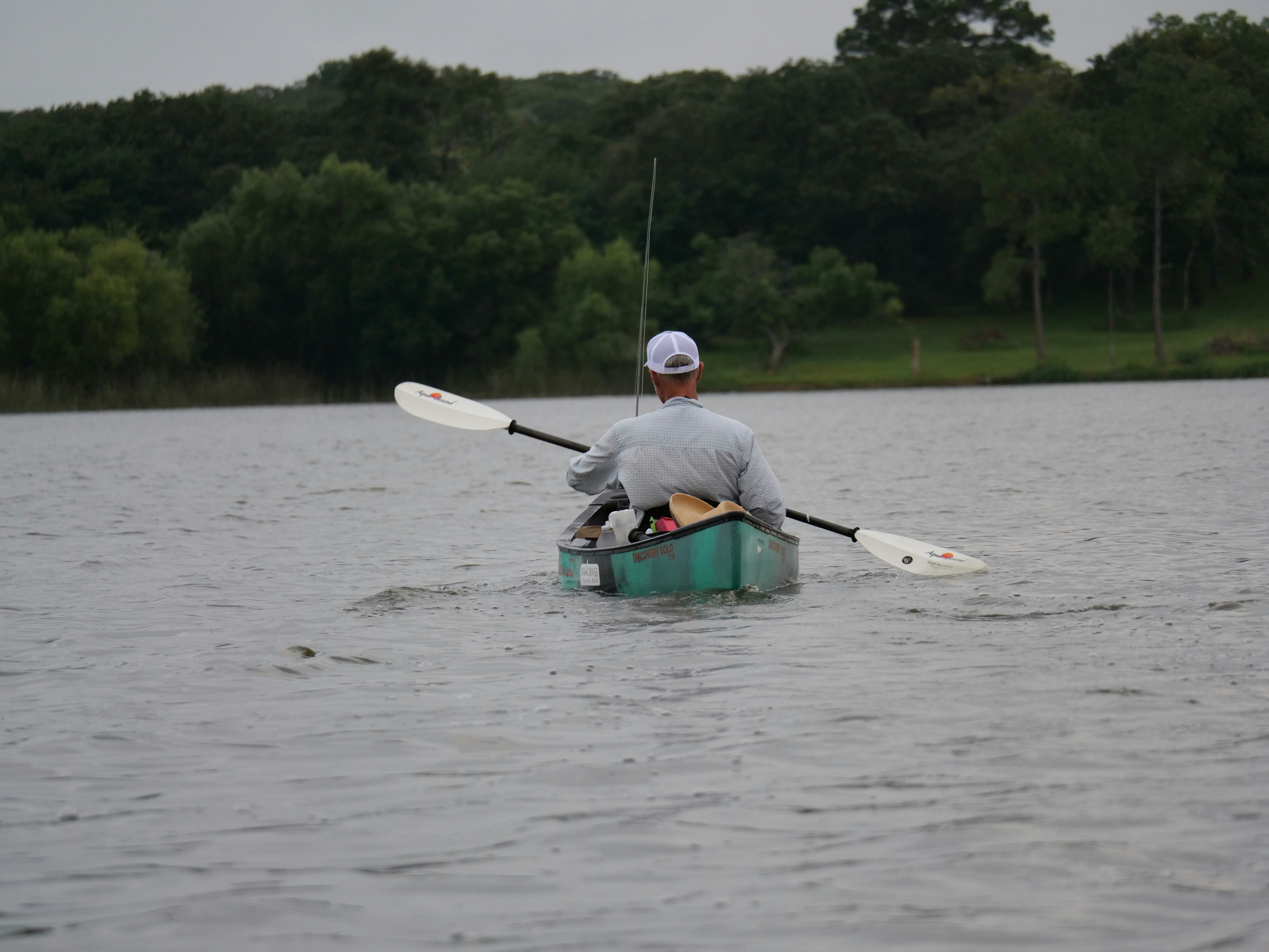 Man paddling a canoe on a lake