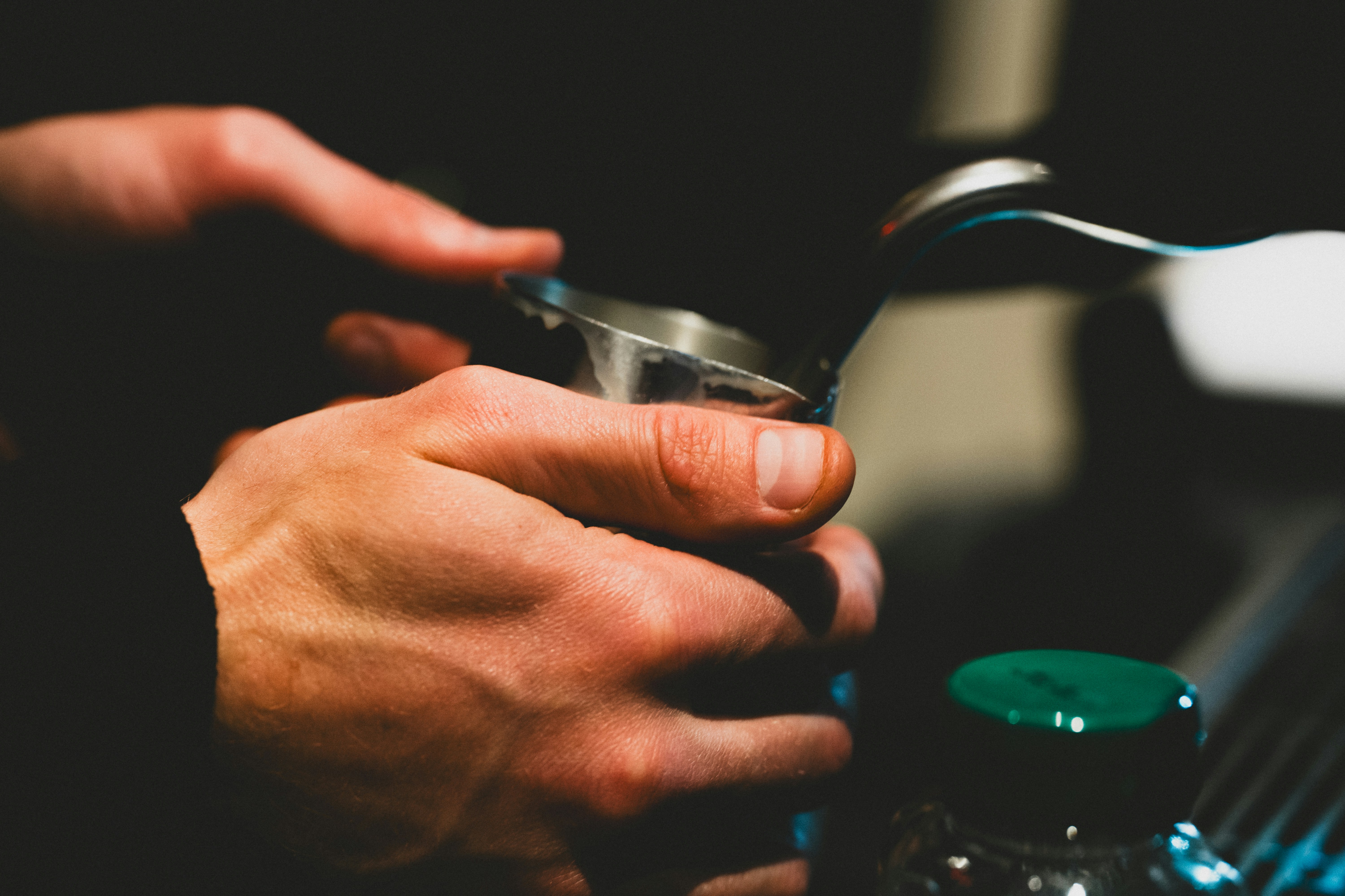 Primer plano de un barista apisonando posos de café, lo que representa el arte de la cultura cafetera moderna.
