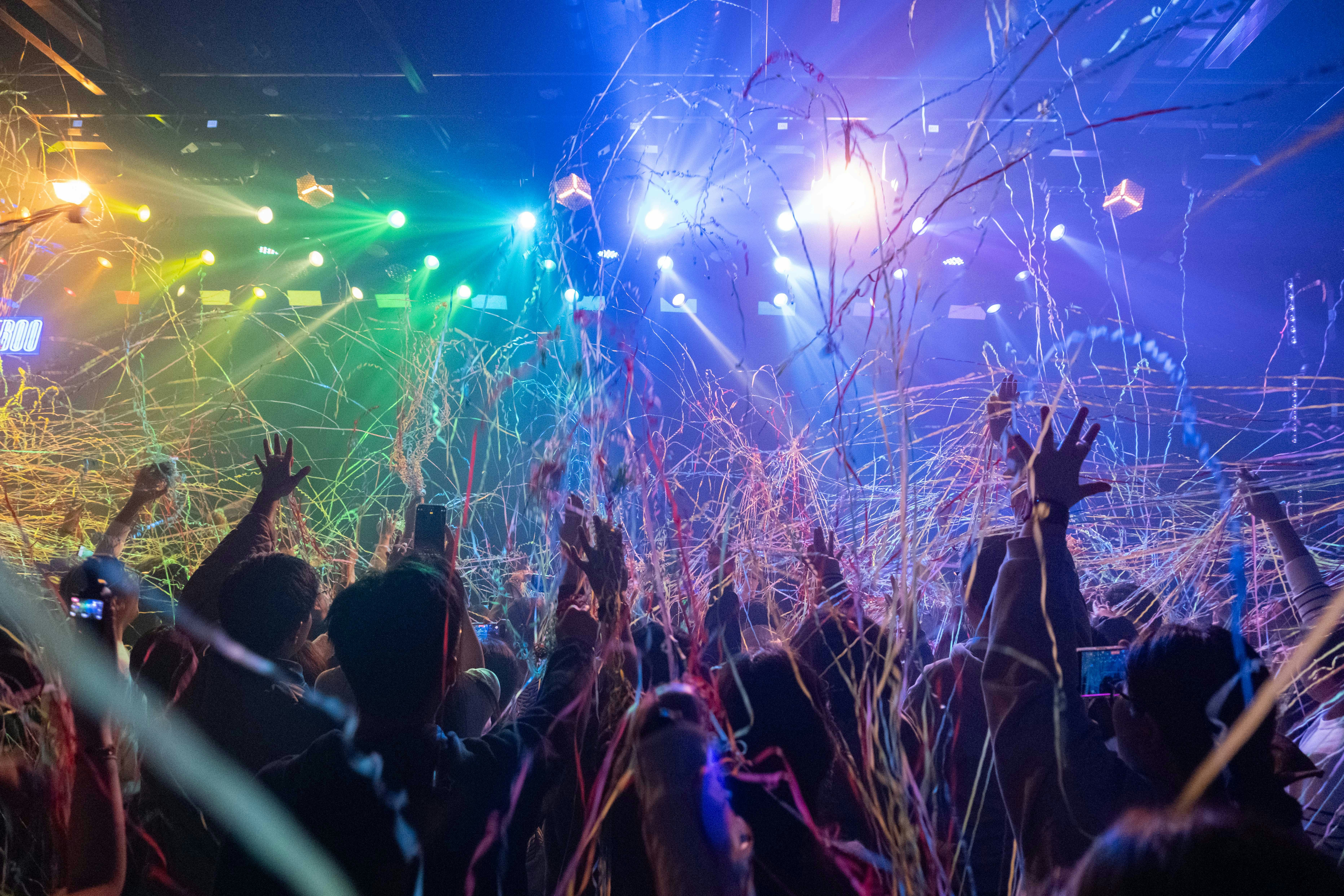 Crowd celebrating with confetti and colorful lights