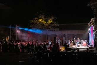 An outdoor concert with a band performing at night.