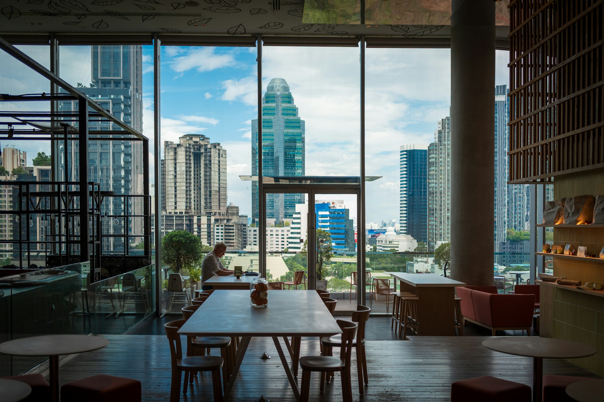 Modern cafe interior with city view through windows