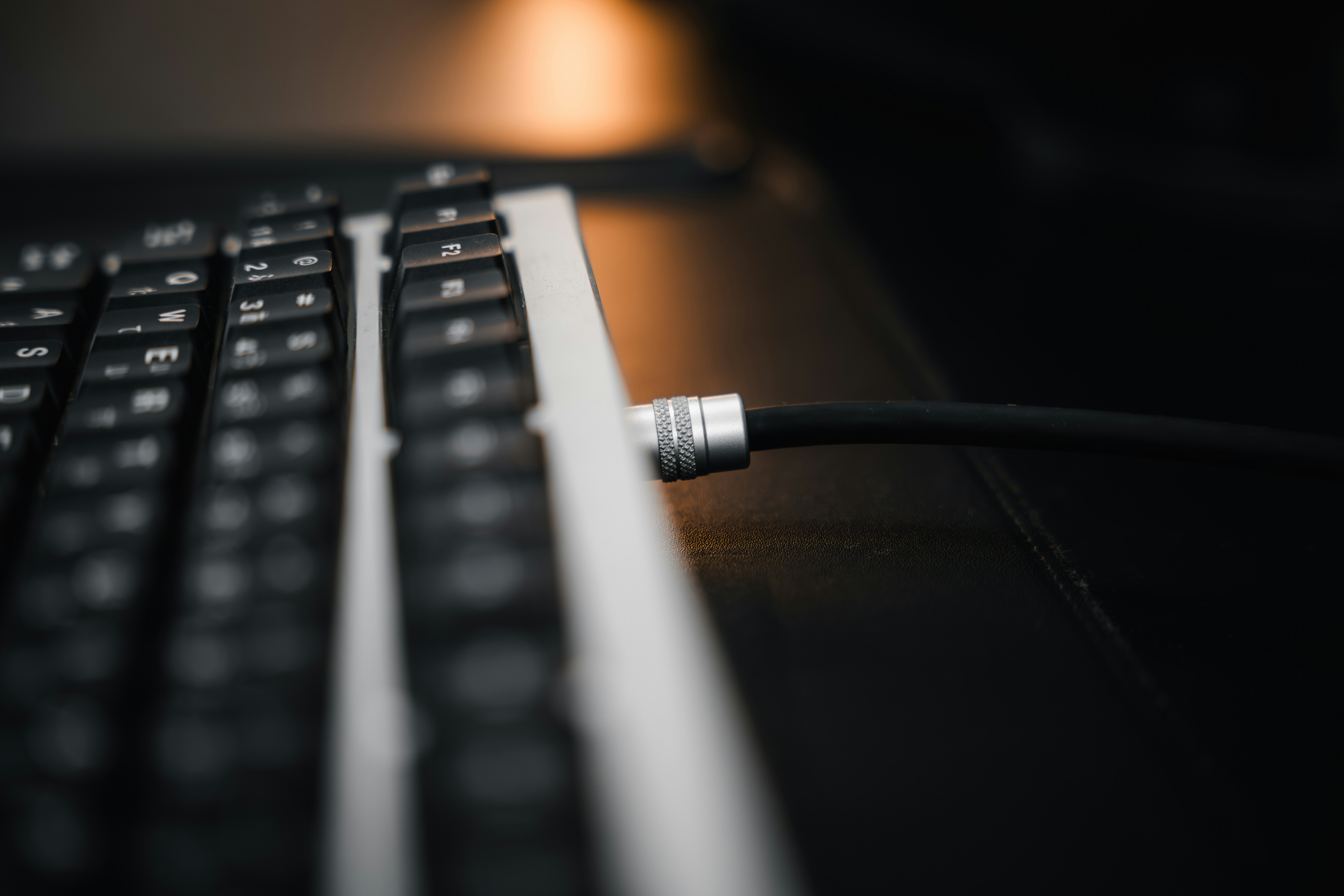 Close-up of a keyboard with a cable plugged in.