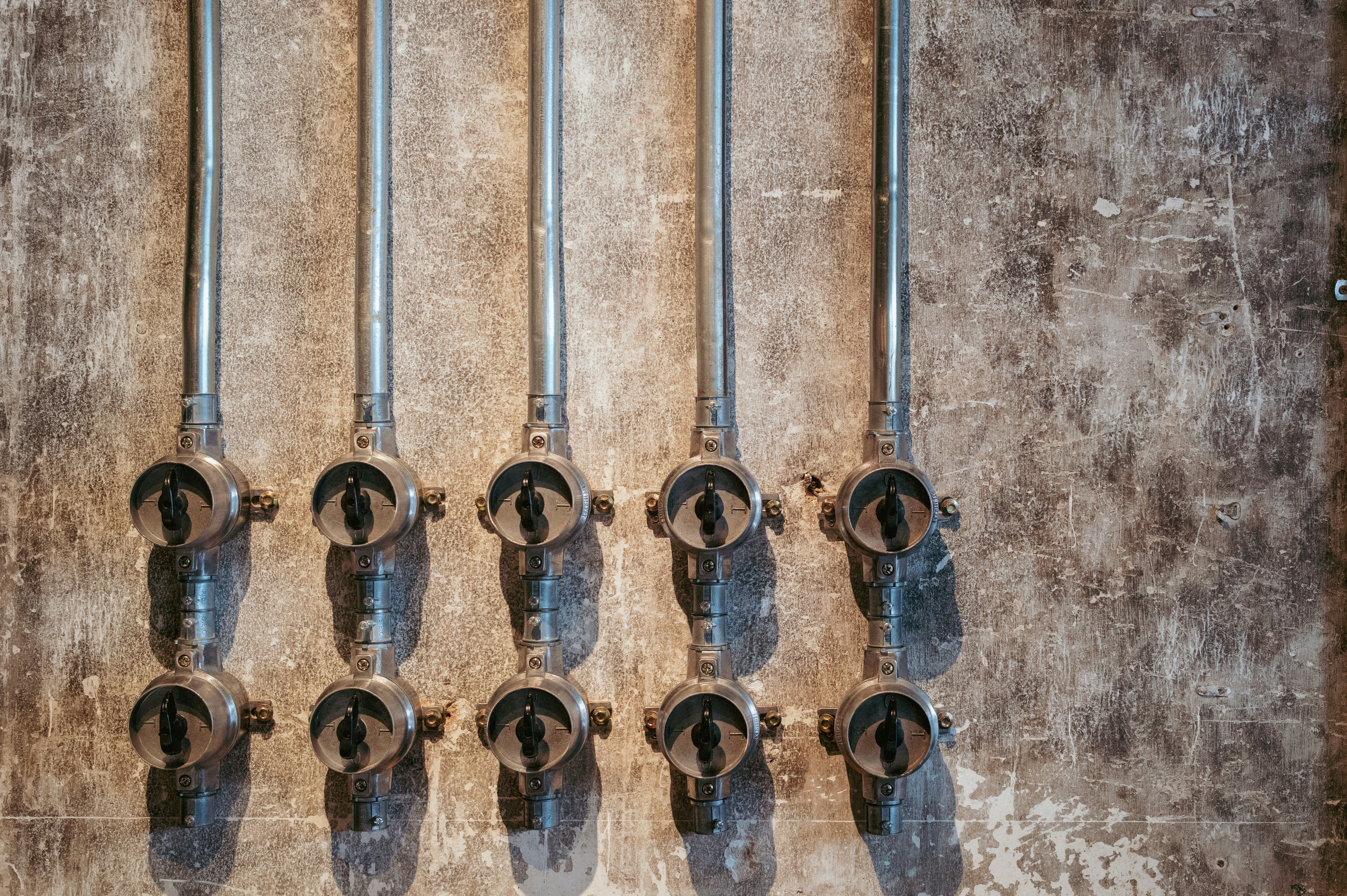 Row of vintage electrical switches on a wall.