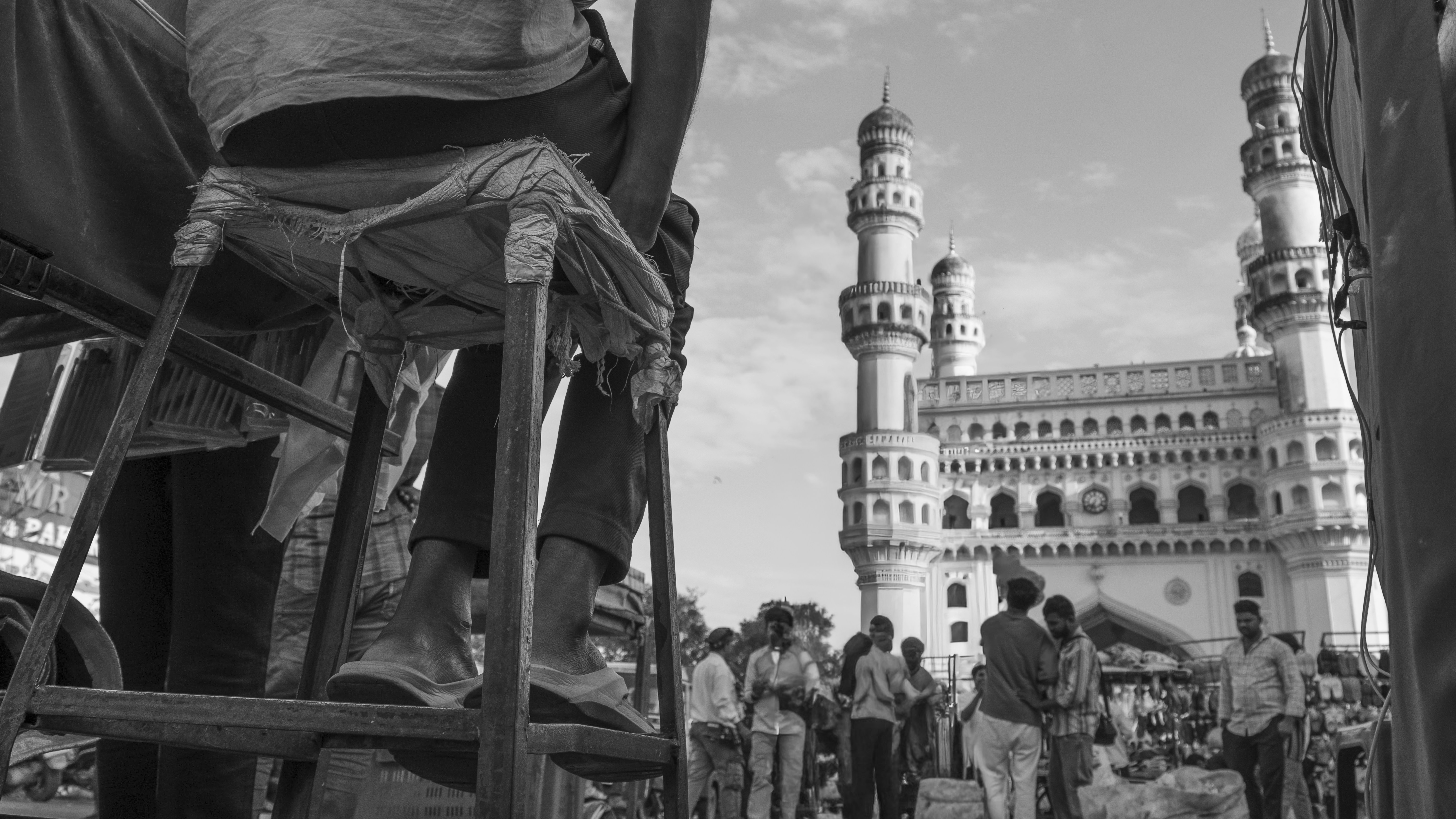 People gather near a historic monument in black and white.