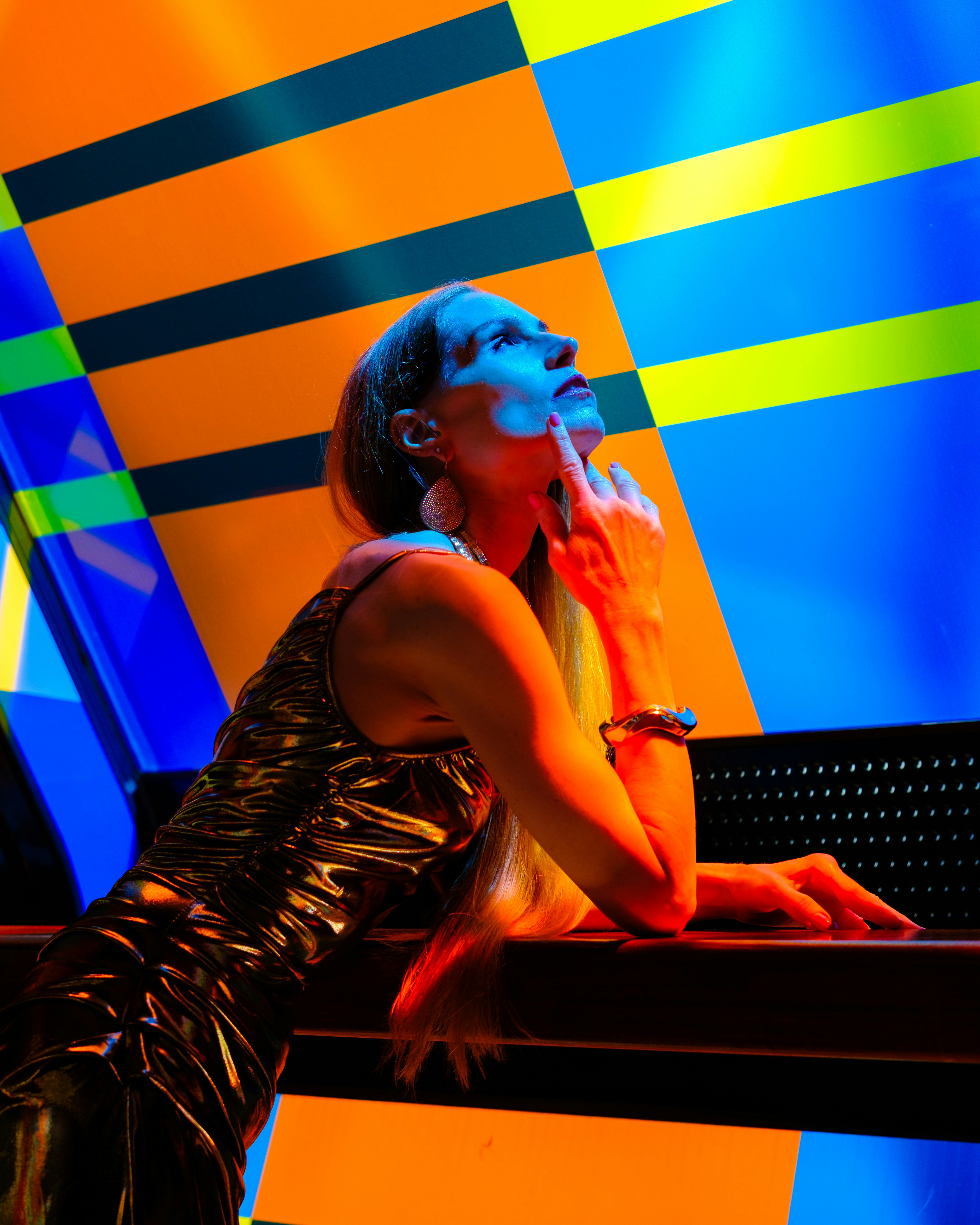 Woman in metallic dress against geometric background