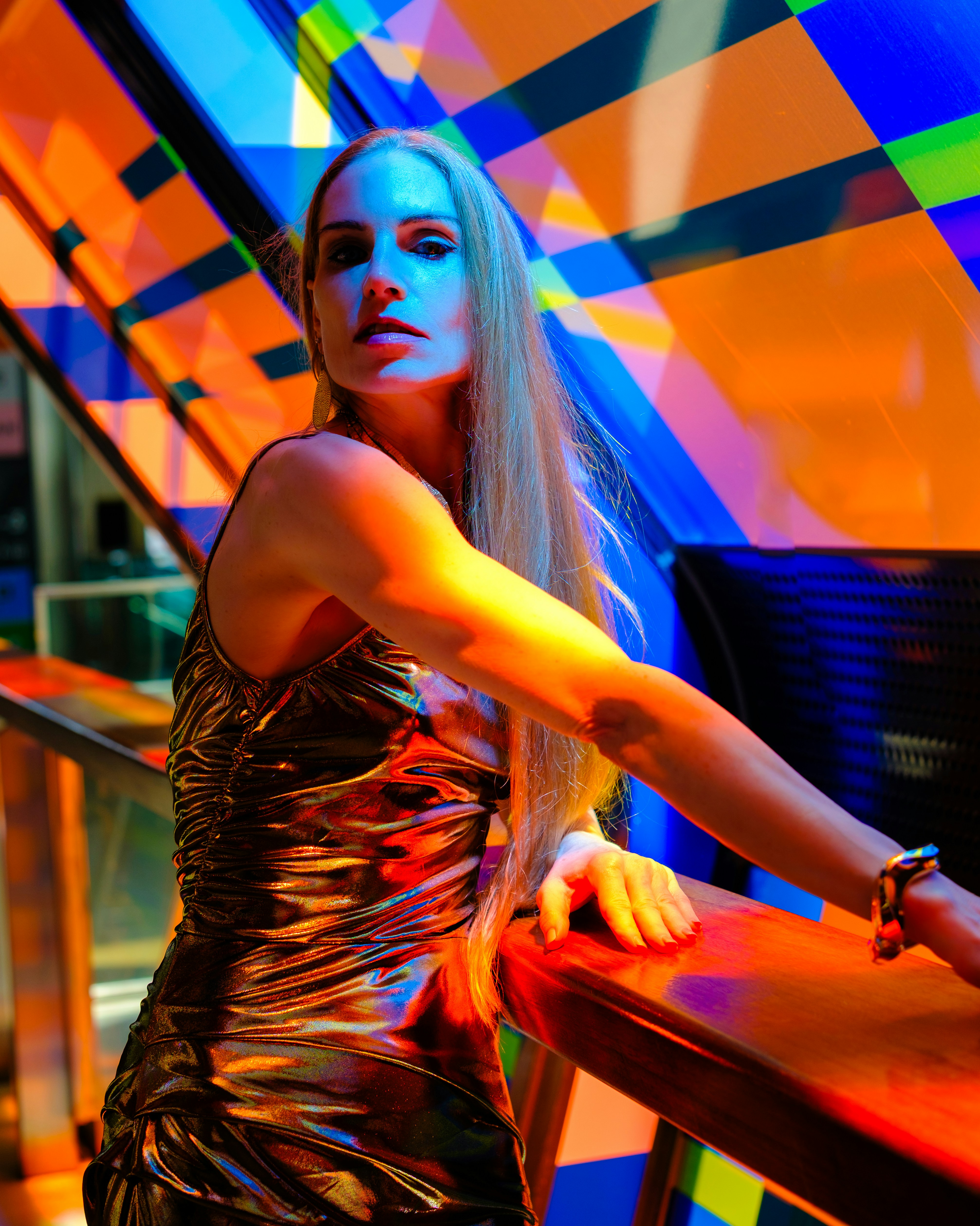Woman in sparkly dress against colorful geometric background