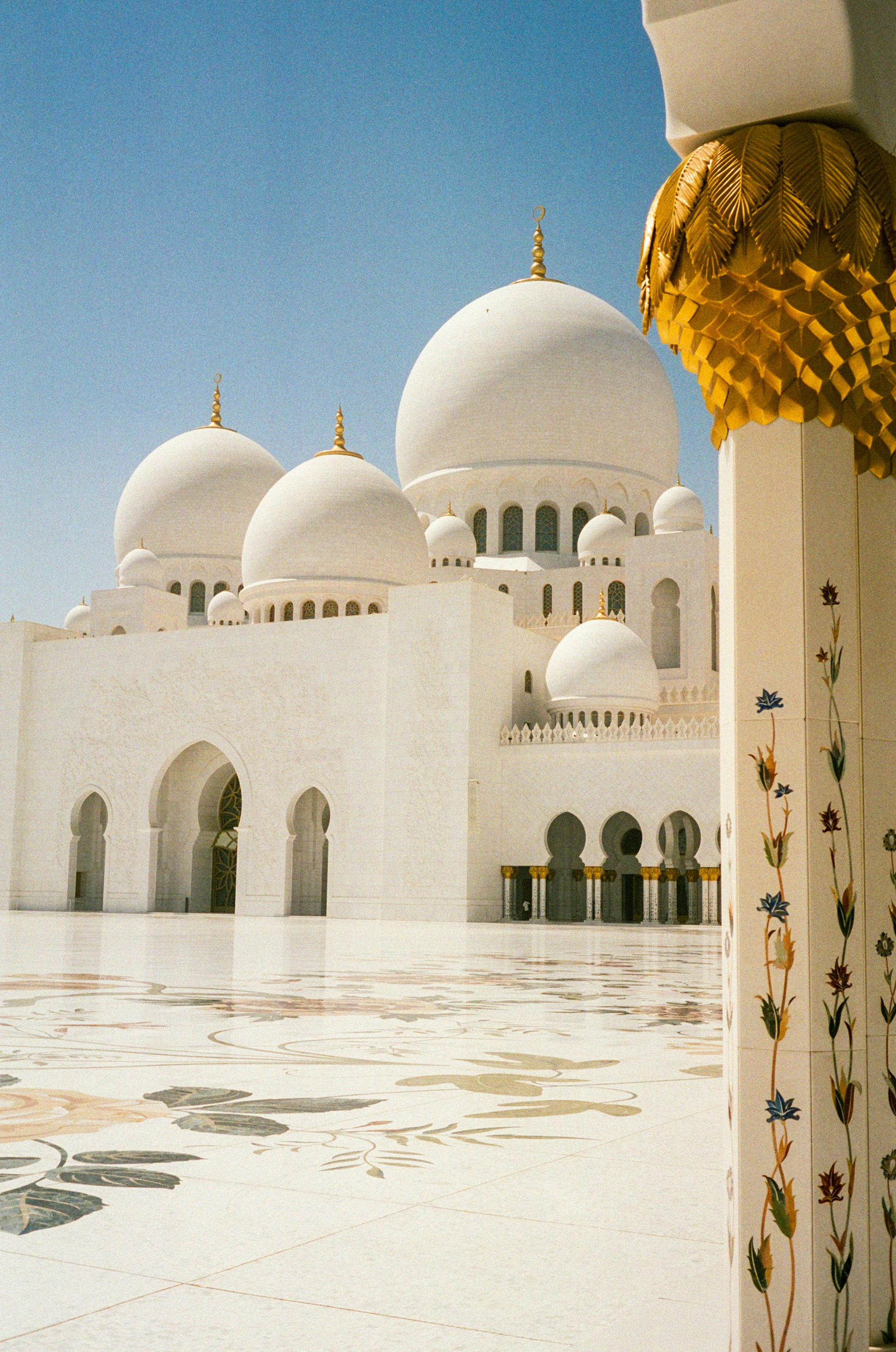 White mosque with ornate columns under a blue sky