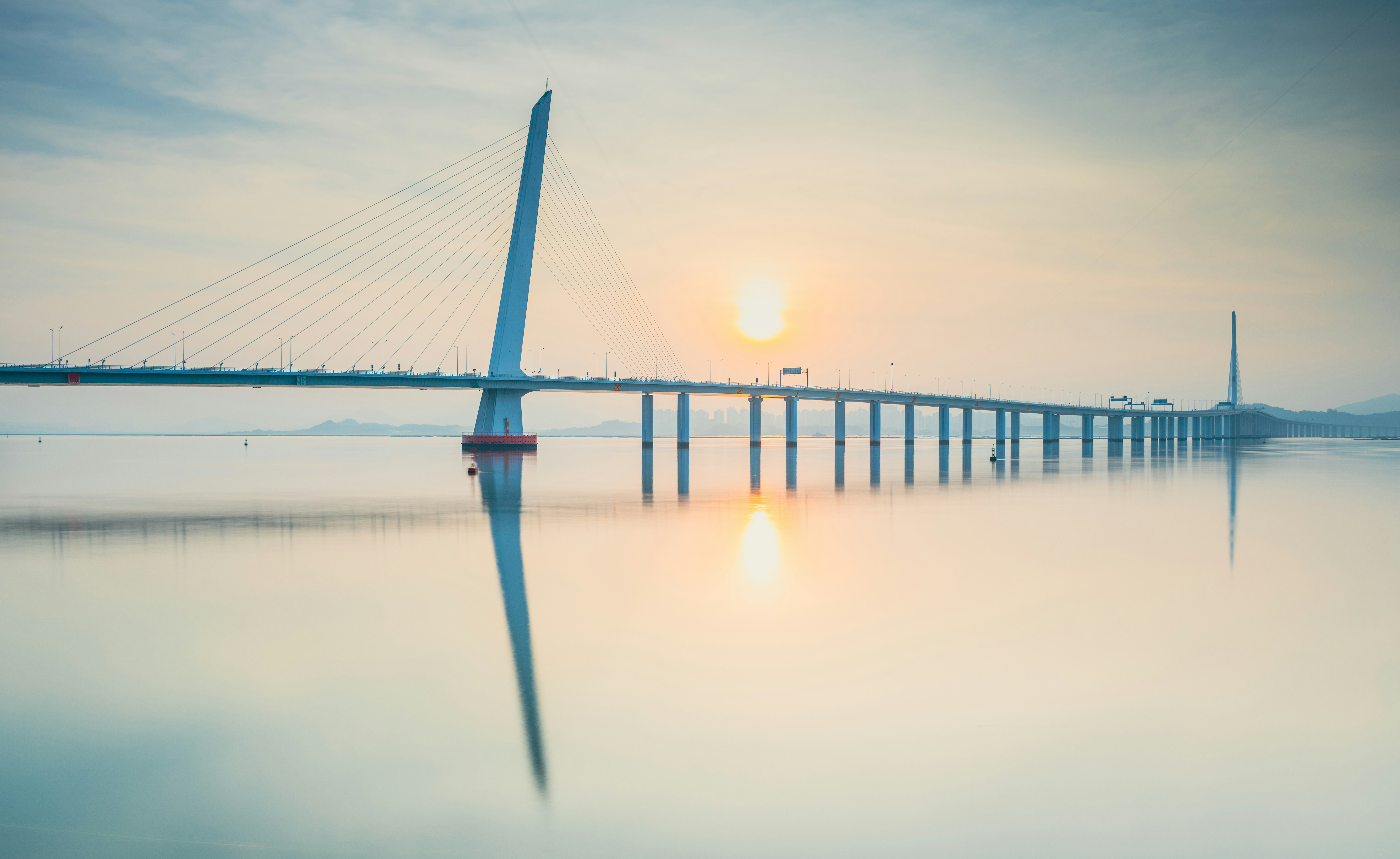 Modern bridge over calm water at sunrise
