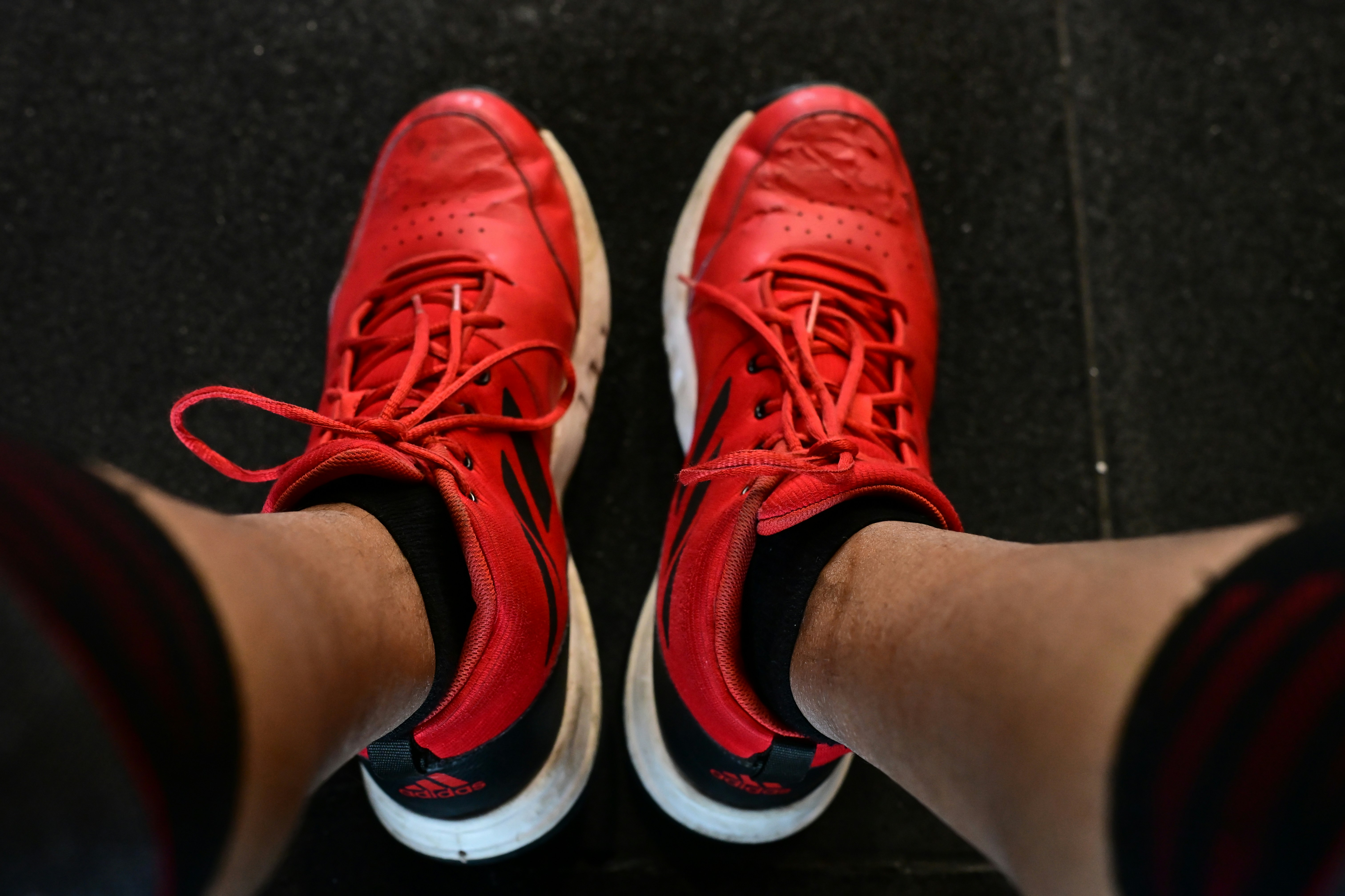 Pair of red athletic shoes with white soles.