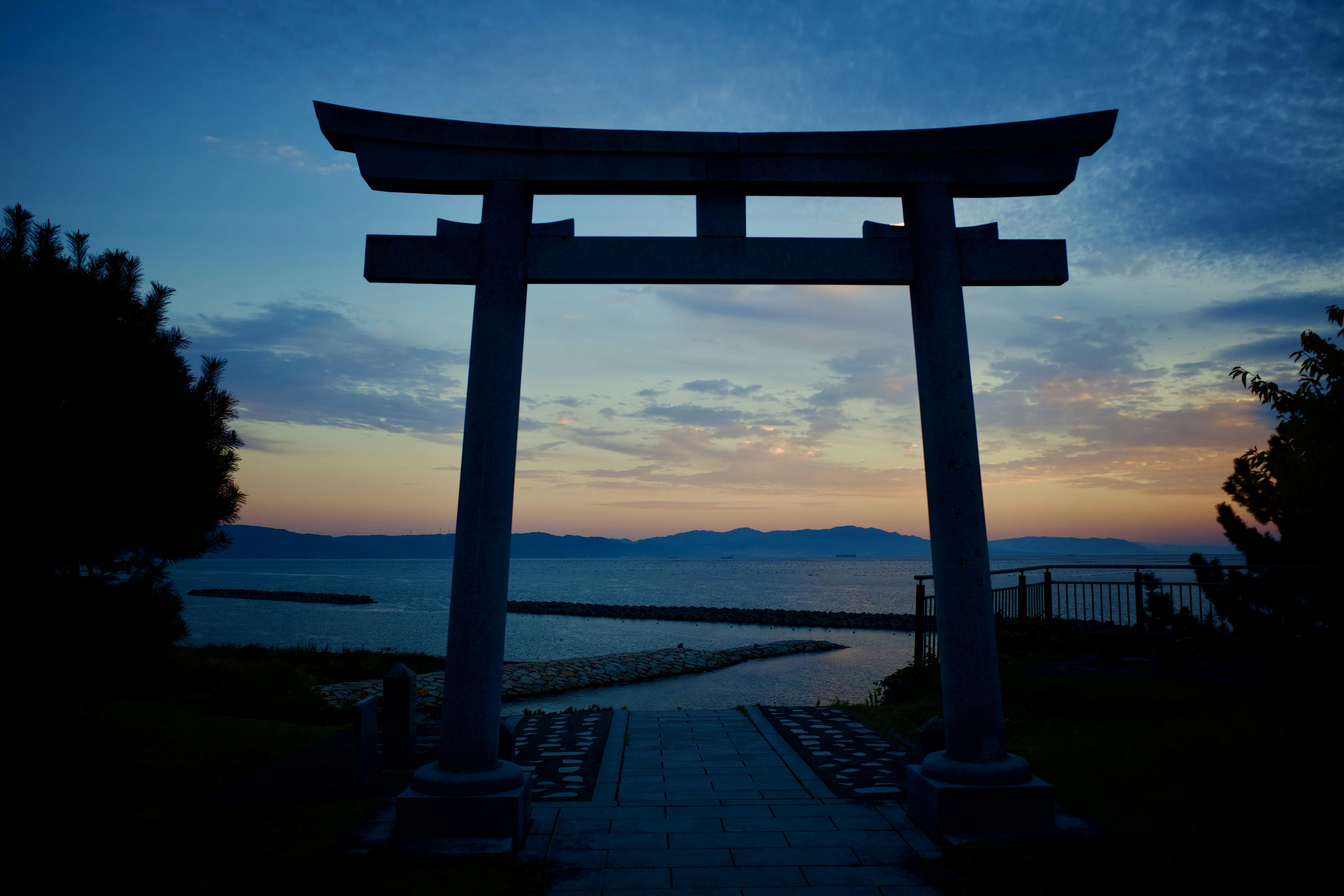 Puerta Torii al atardecer sobre el océano.