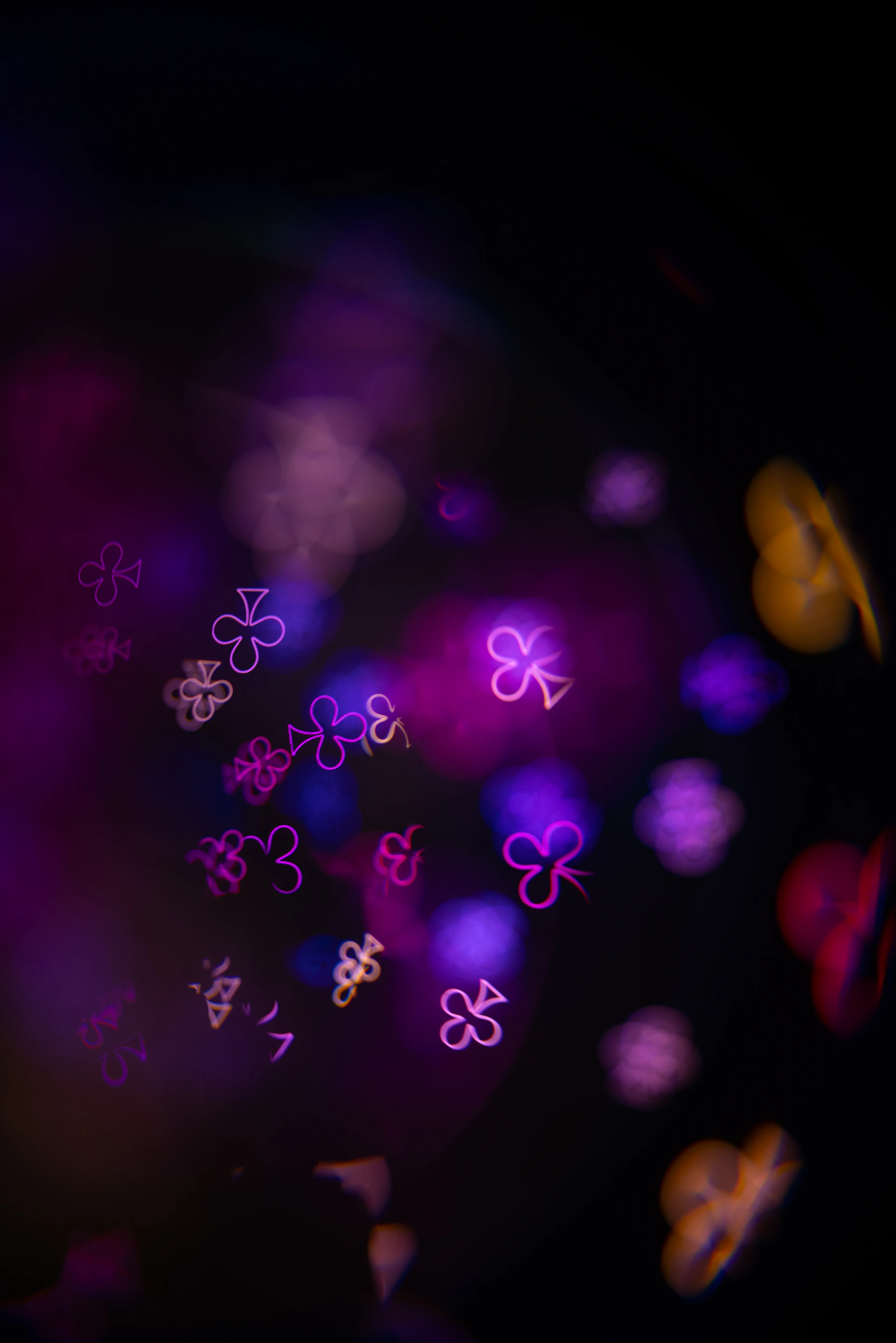 Abstract background of glowing purple and yellow clover shapes.