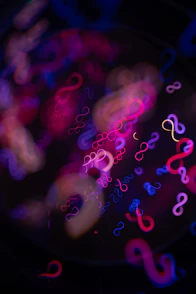 Abstract infinity symbols in neon pink and blue lights.