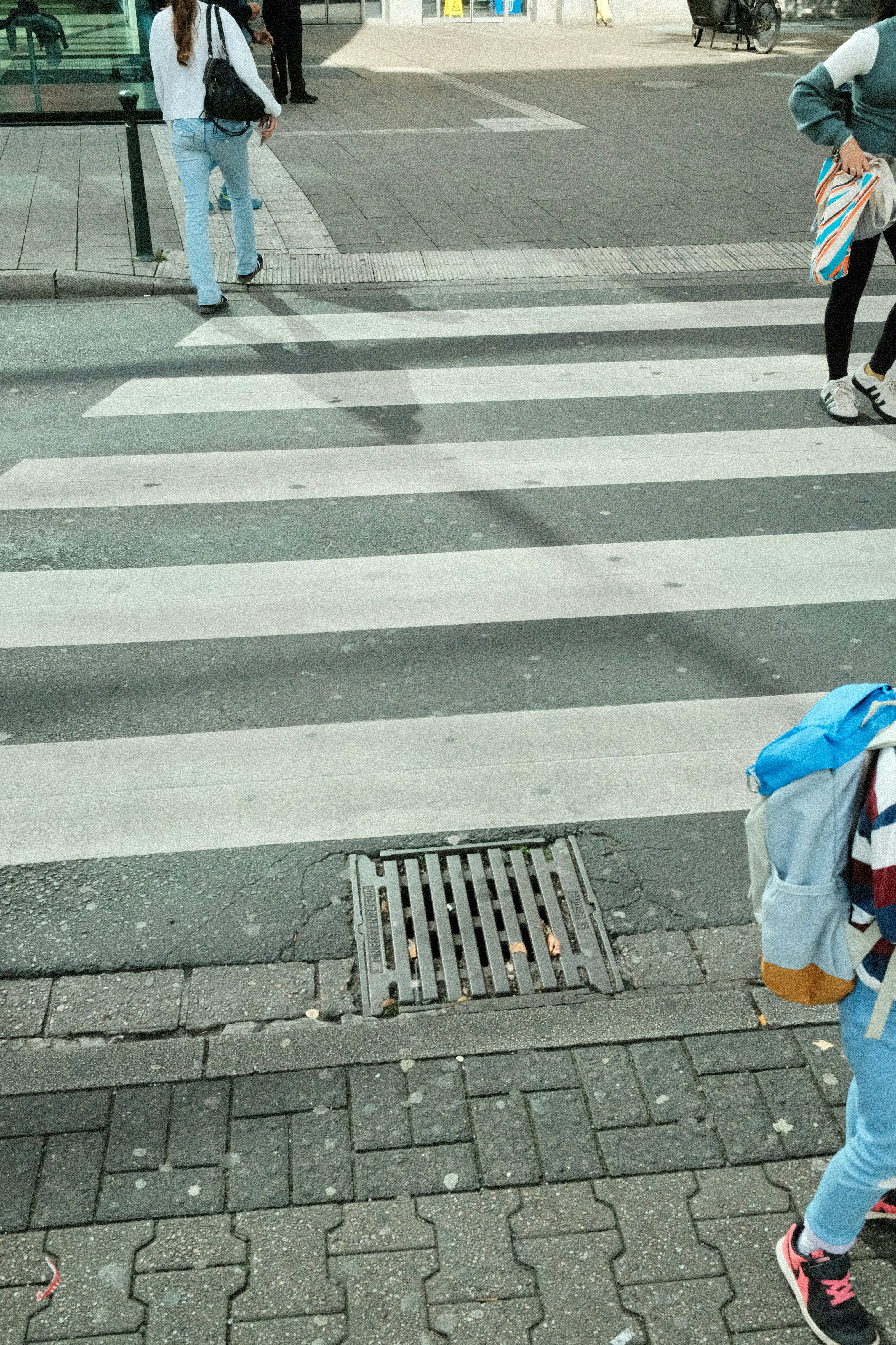 People crossing a street at a crosswalk.