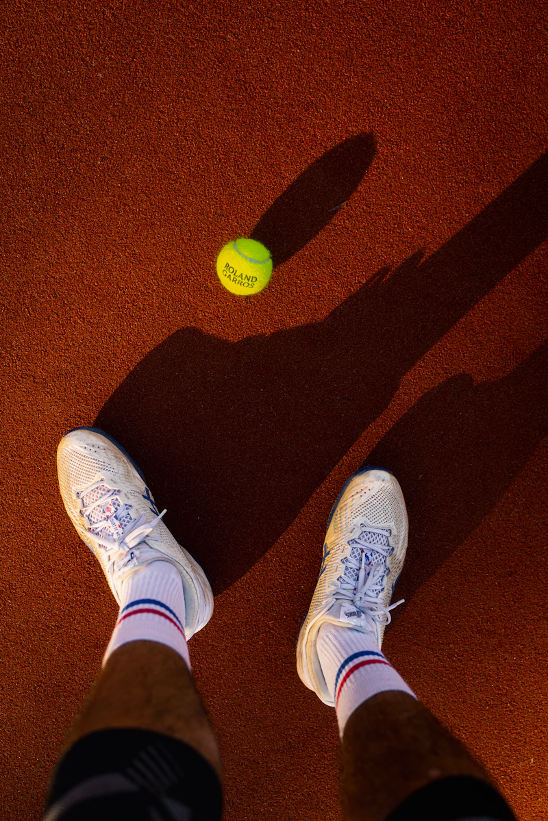 Tennis ball and a player's feet on clay