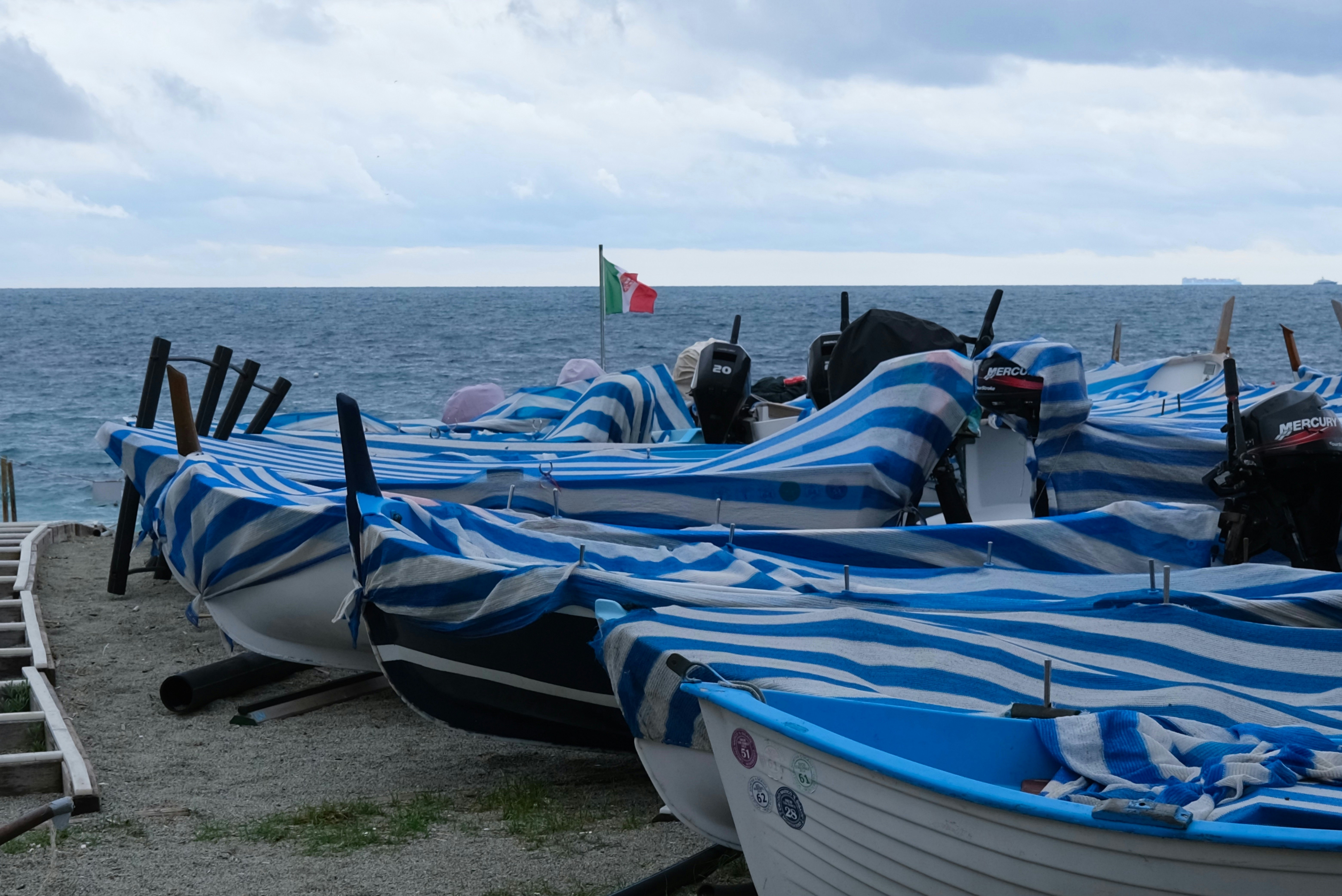 Pescherecci ormeggiati in banchina con i teli di copertura