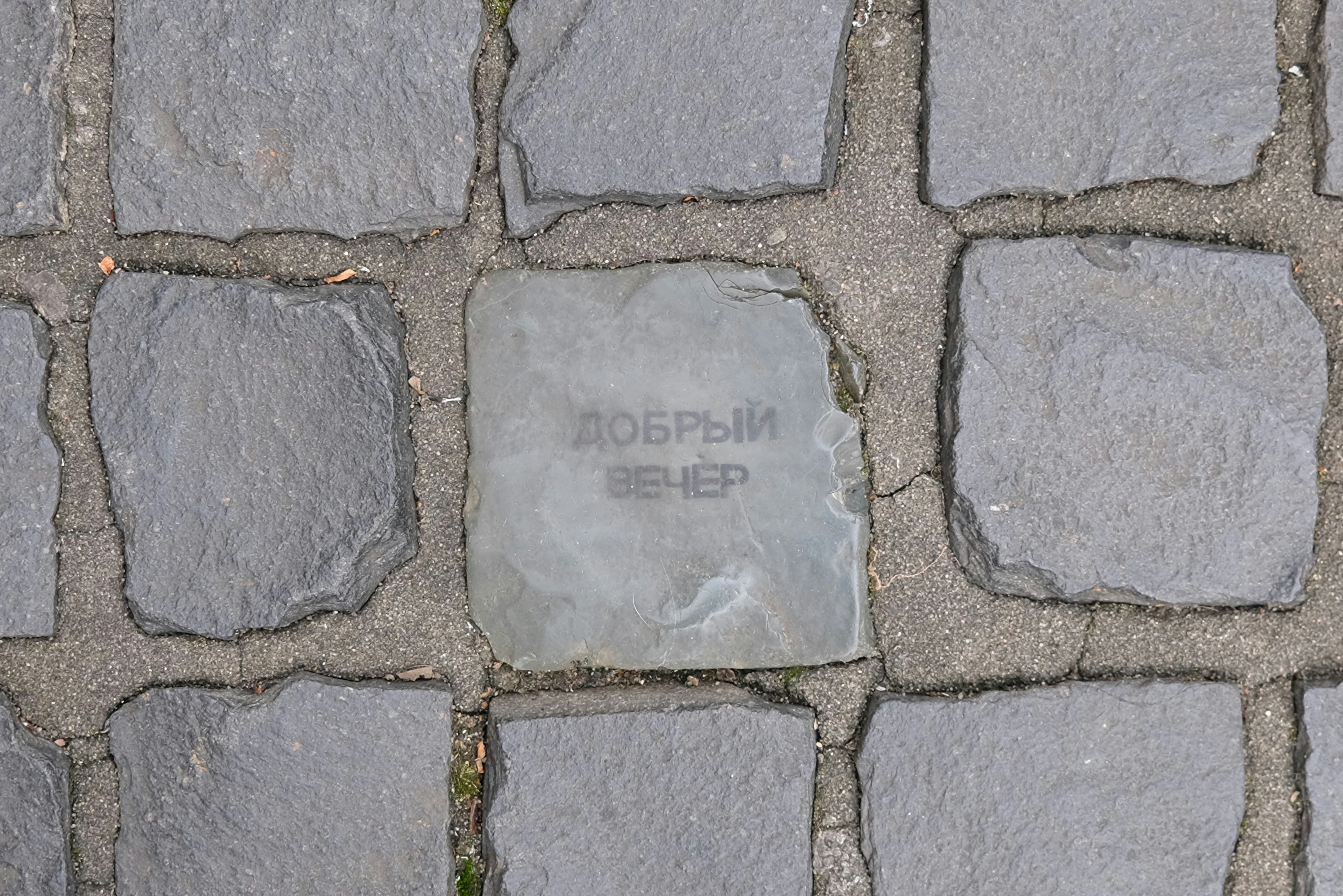 Cobblestone pavement with inscription 'good evening' in russian.