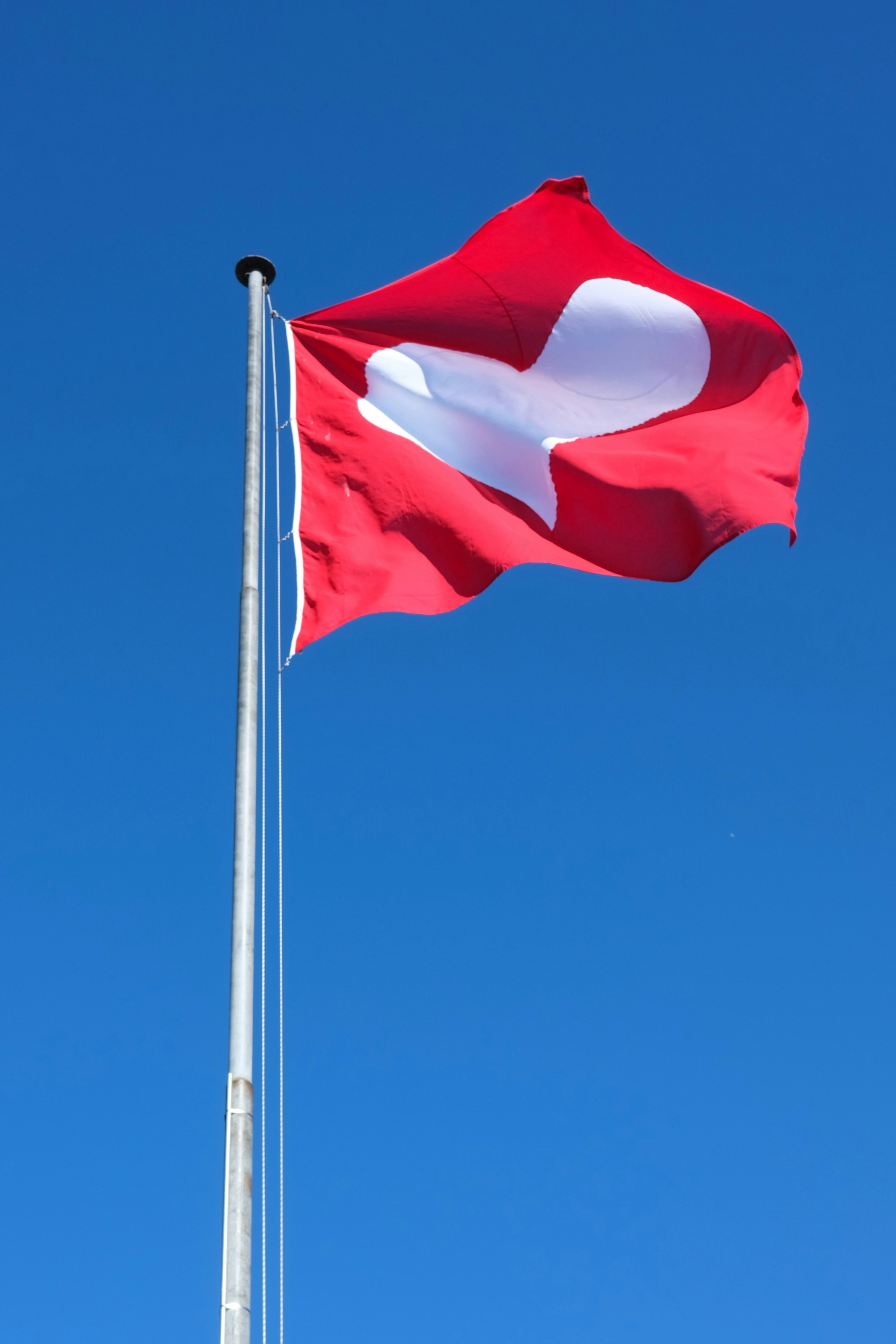 Swiss flag waving against a clear blue sky
