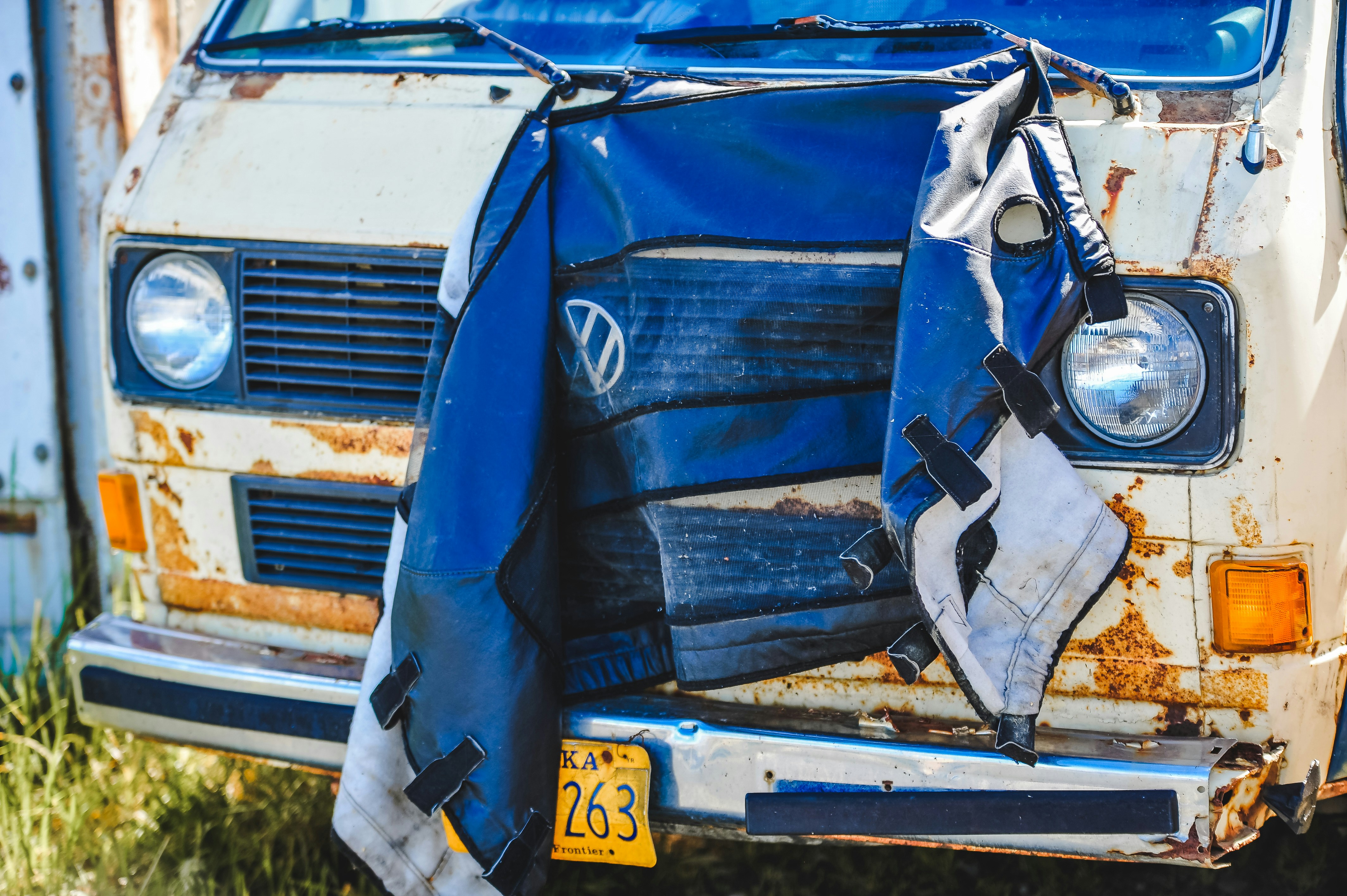 Damaged vintage volkswagen van with blue tarp