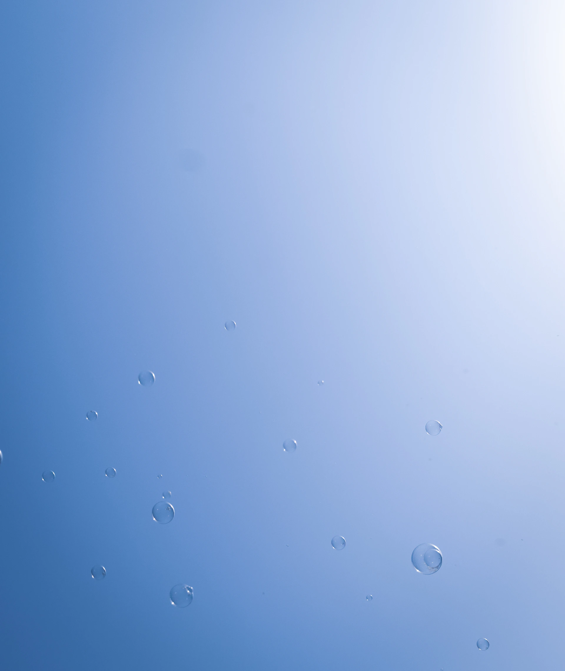 Bubbles floating against a bright blue sky.