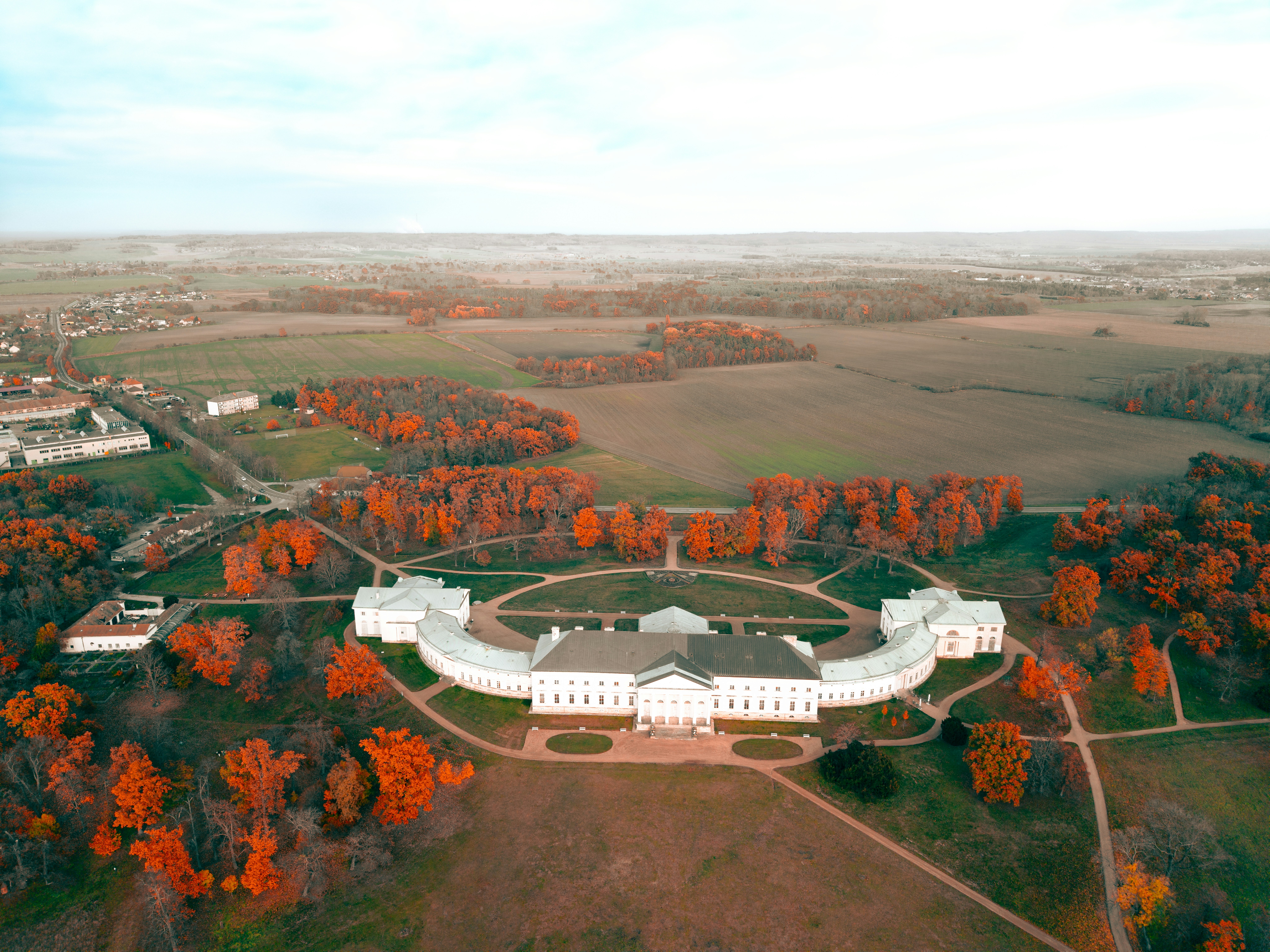 Grand white building surrounded by autumn trees