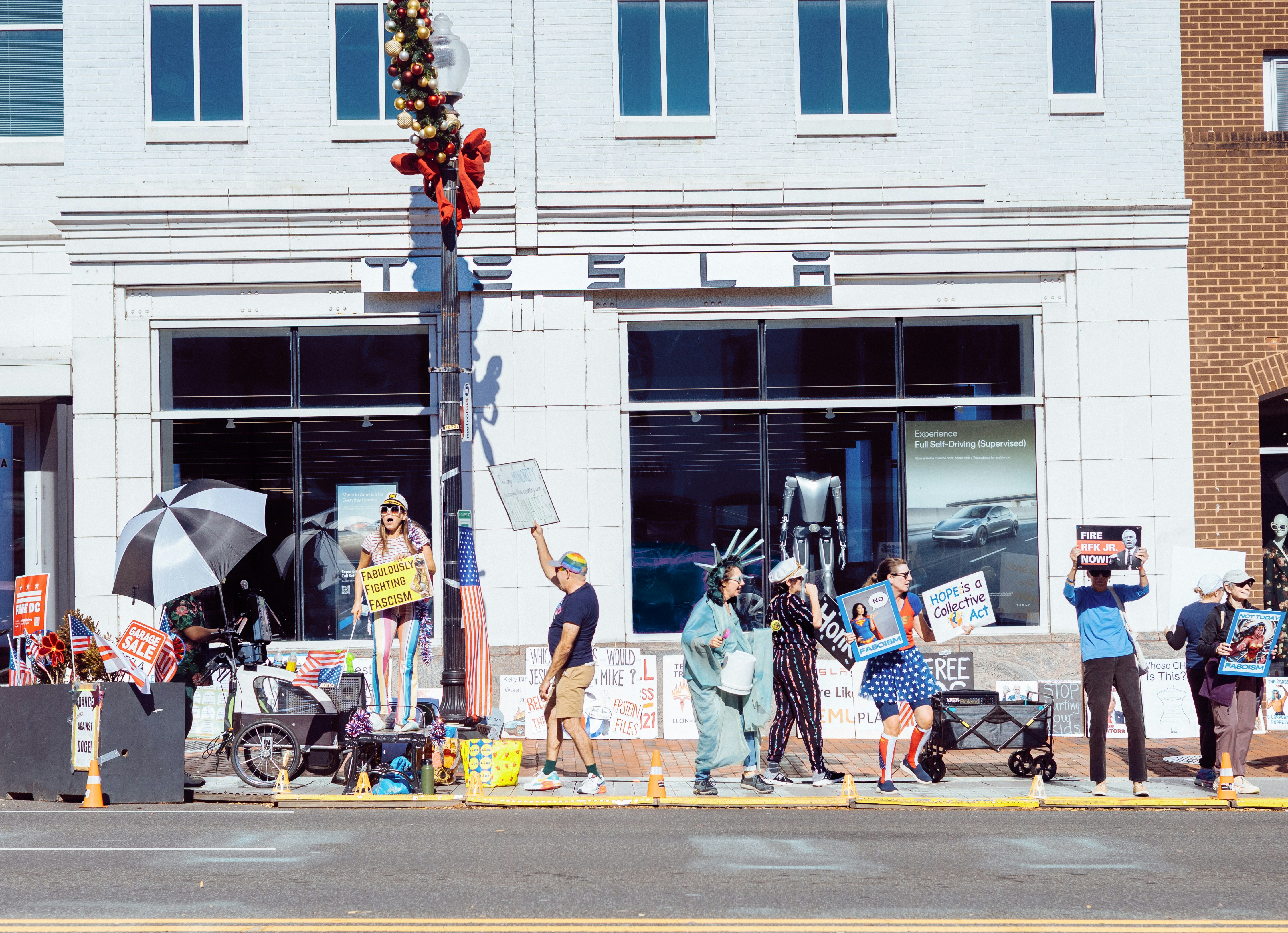 People protest on a city street with signs.