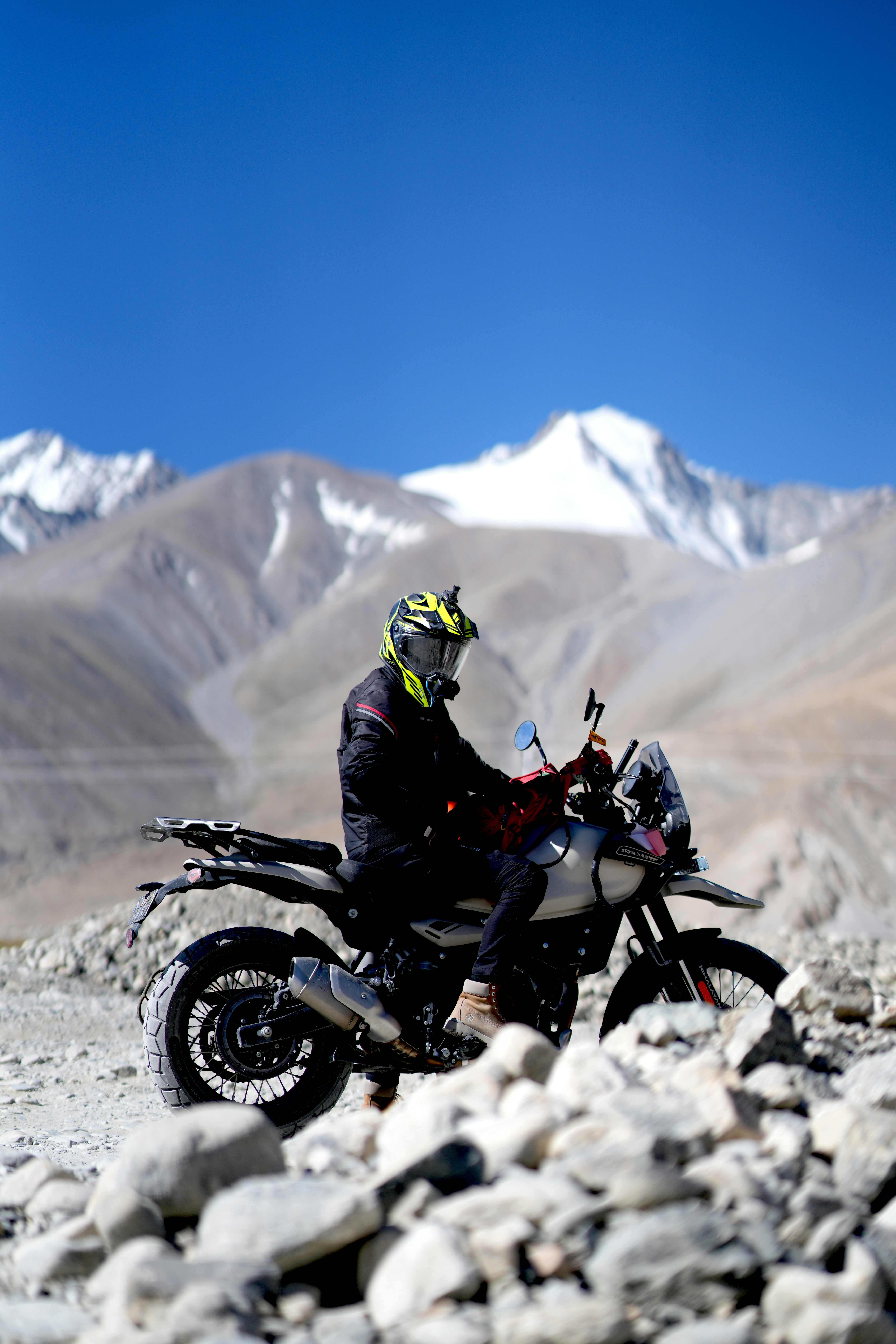 Rider on motorcycle with snowy mountains behind