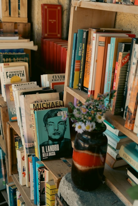 Books on shelves with a vase of flowers