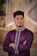 Man in purple kurta with arms crossed.