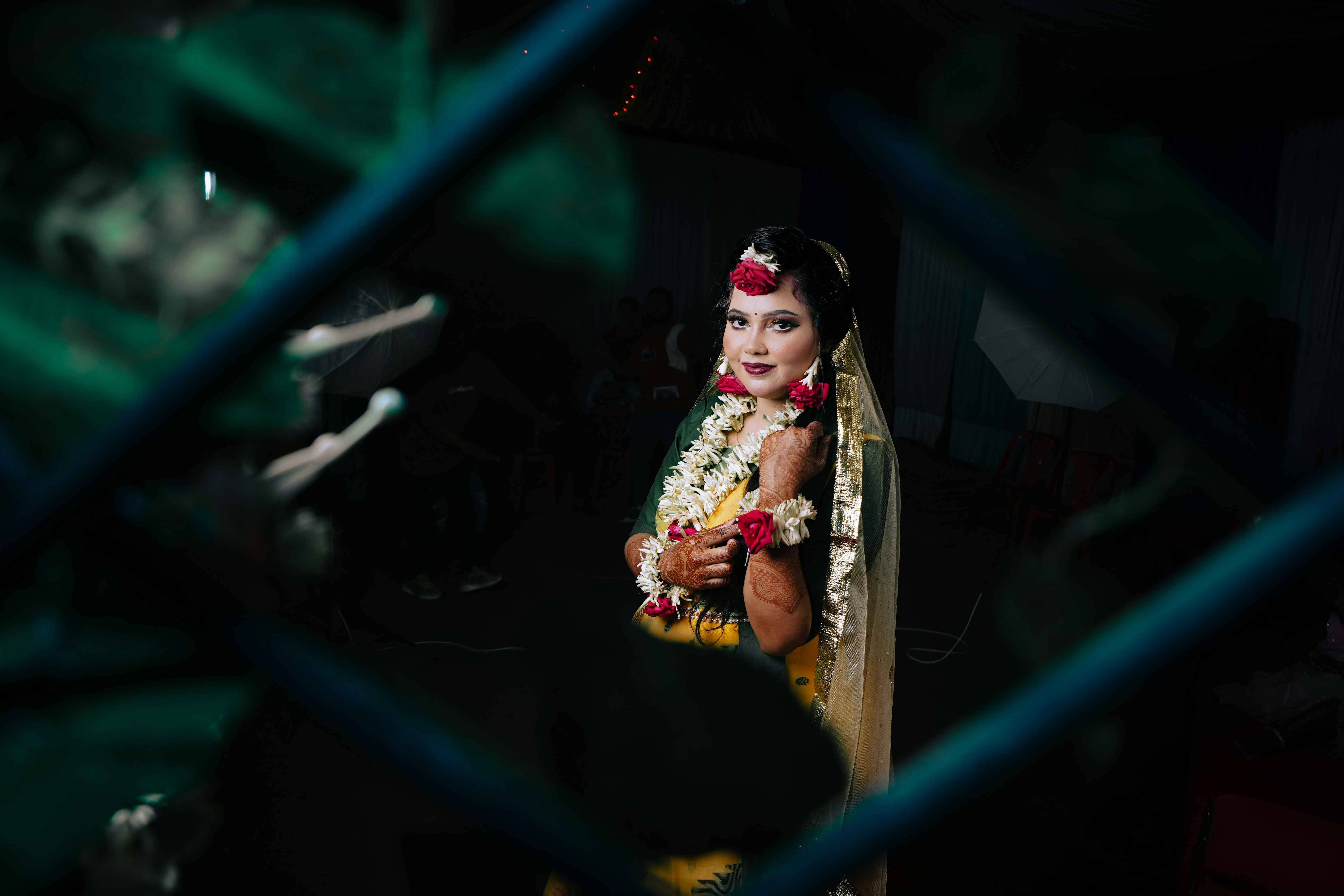A bride in traditional attire with floral jewelry