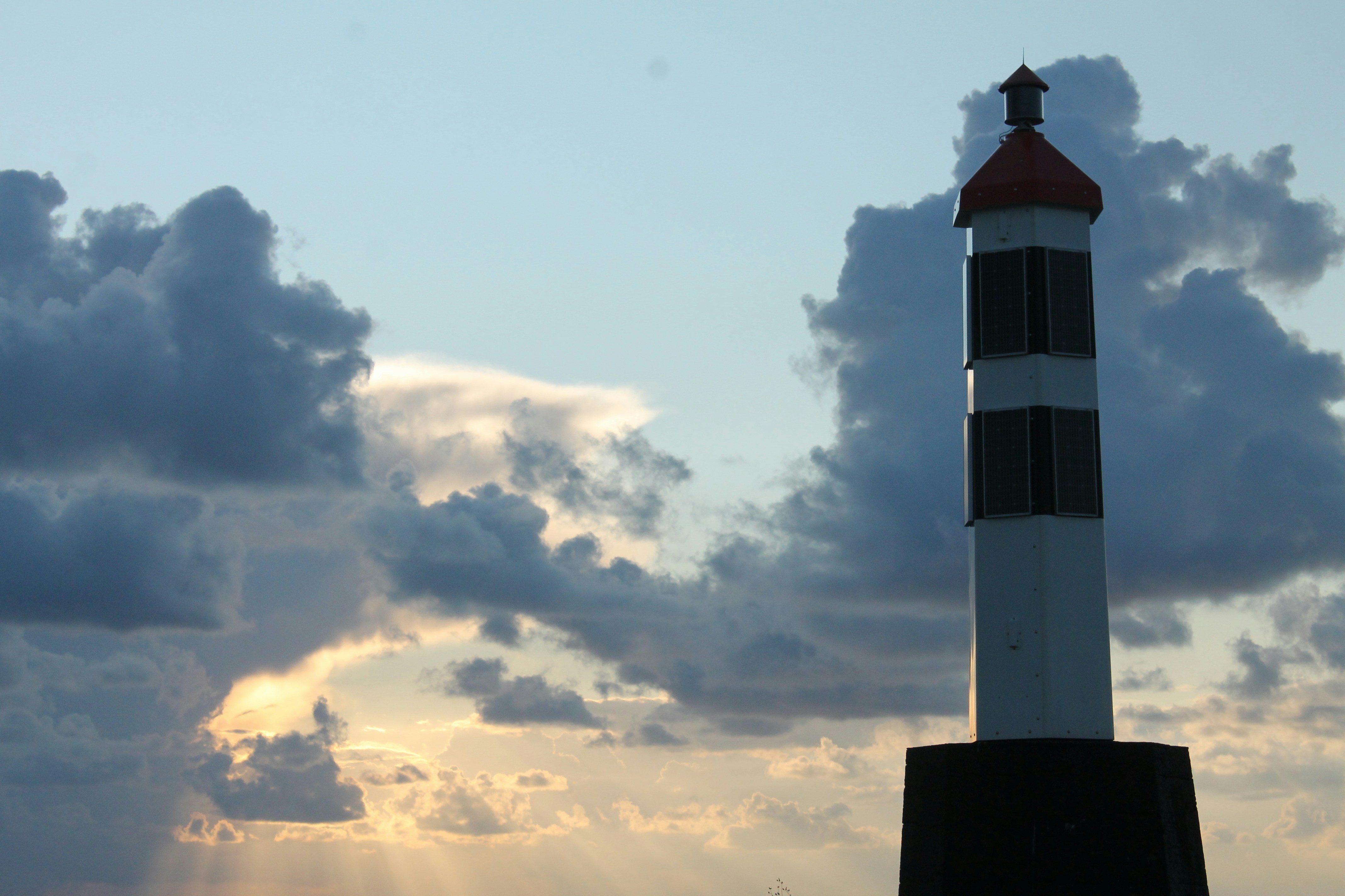 Lighthouse against a cloudy sky at sunset