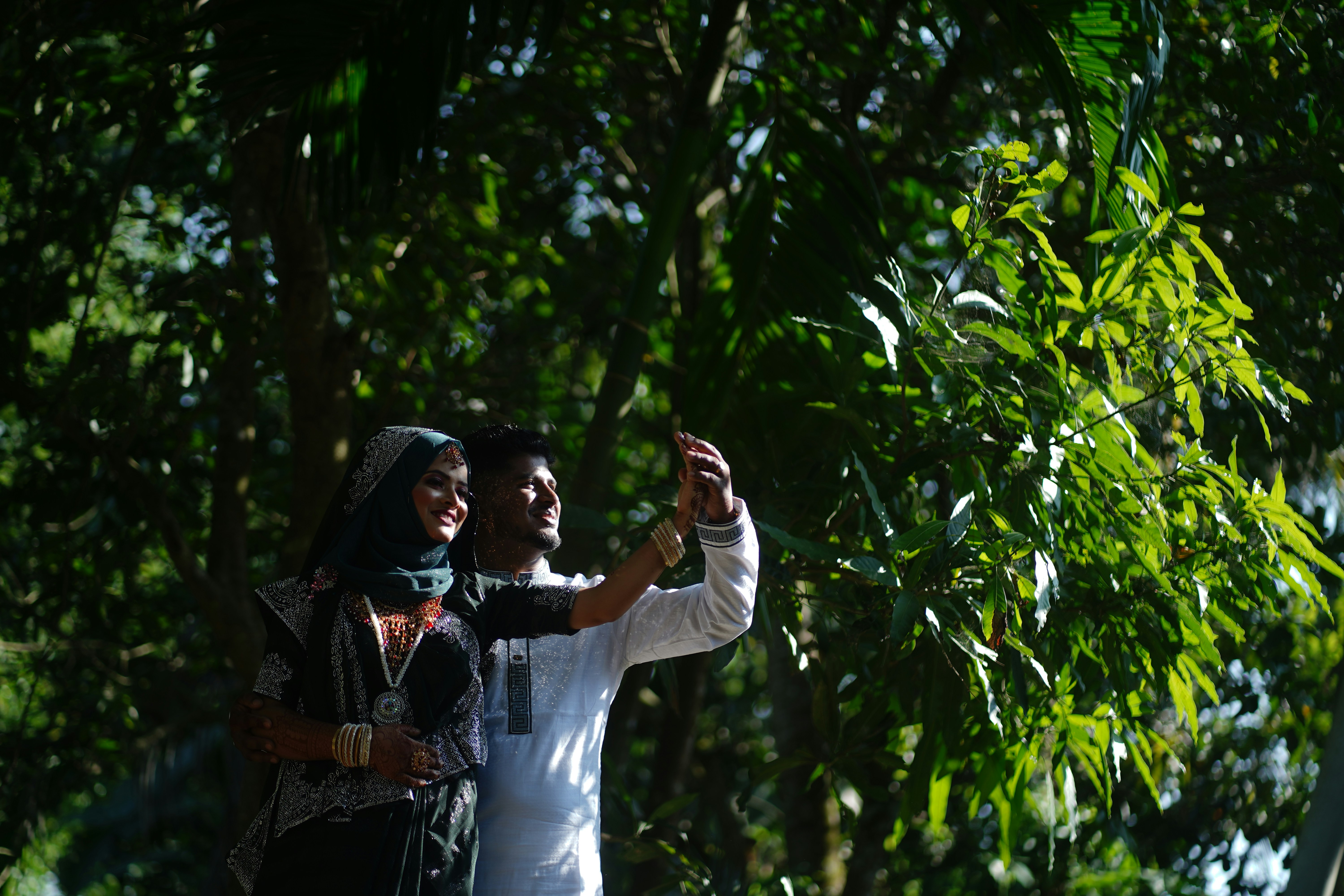 Casal tirando uma selfie em uma floresta verdejante.