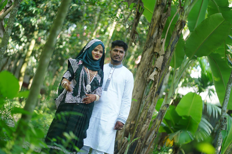 A discerning couple posing in a lush, private forest.