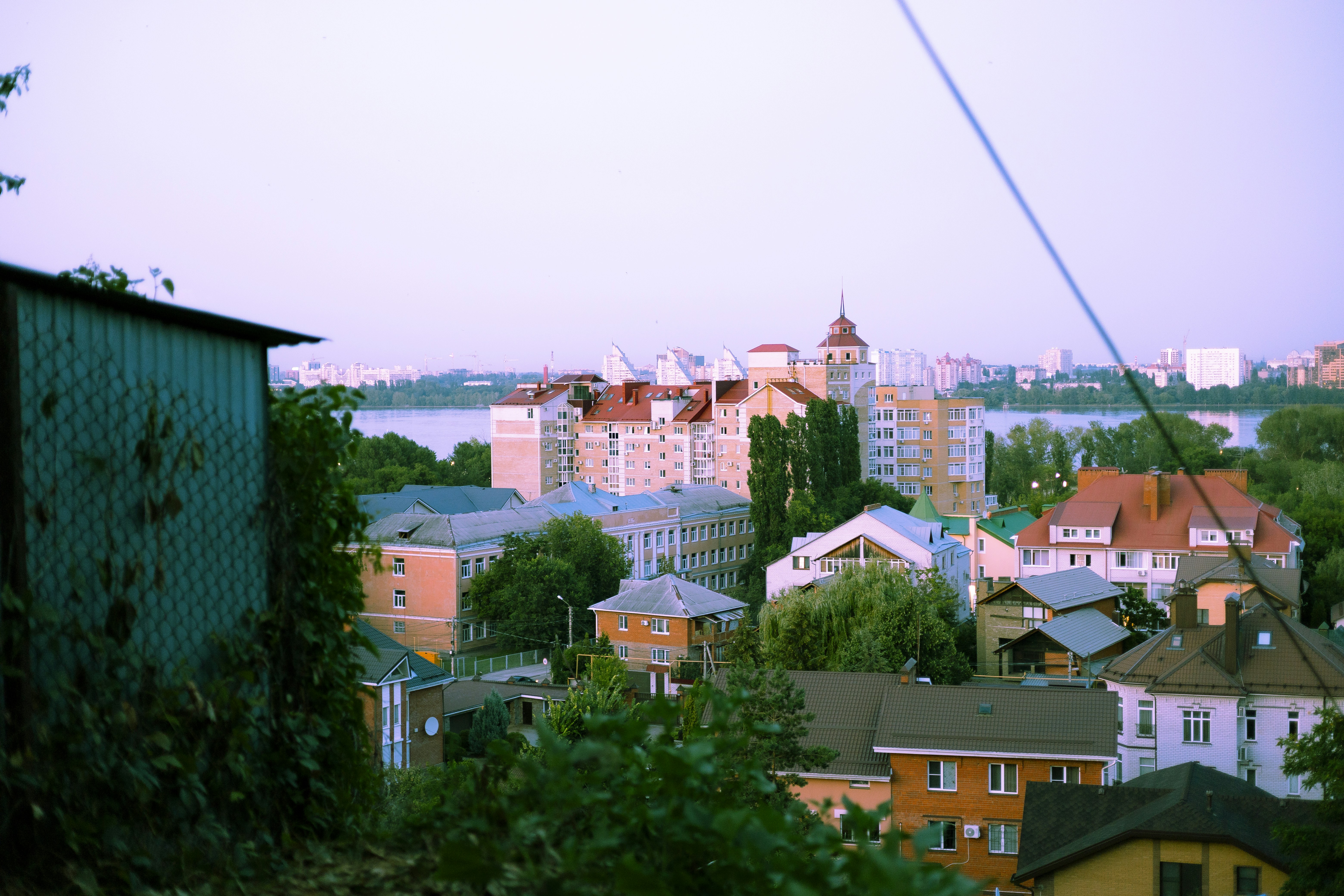 View of buildings and trees near a body of water.