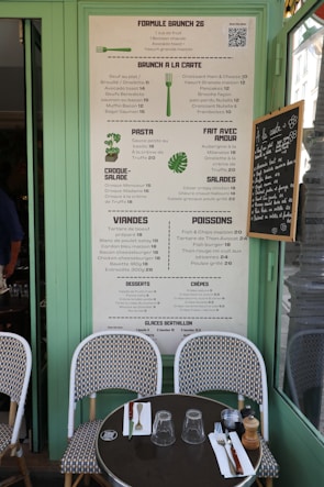 Restaurant menu displayed outside a cafe with tables.