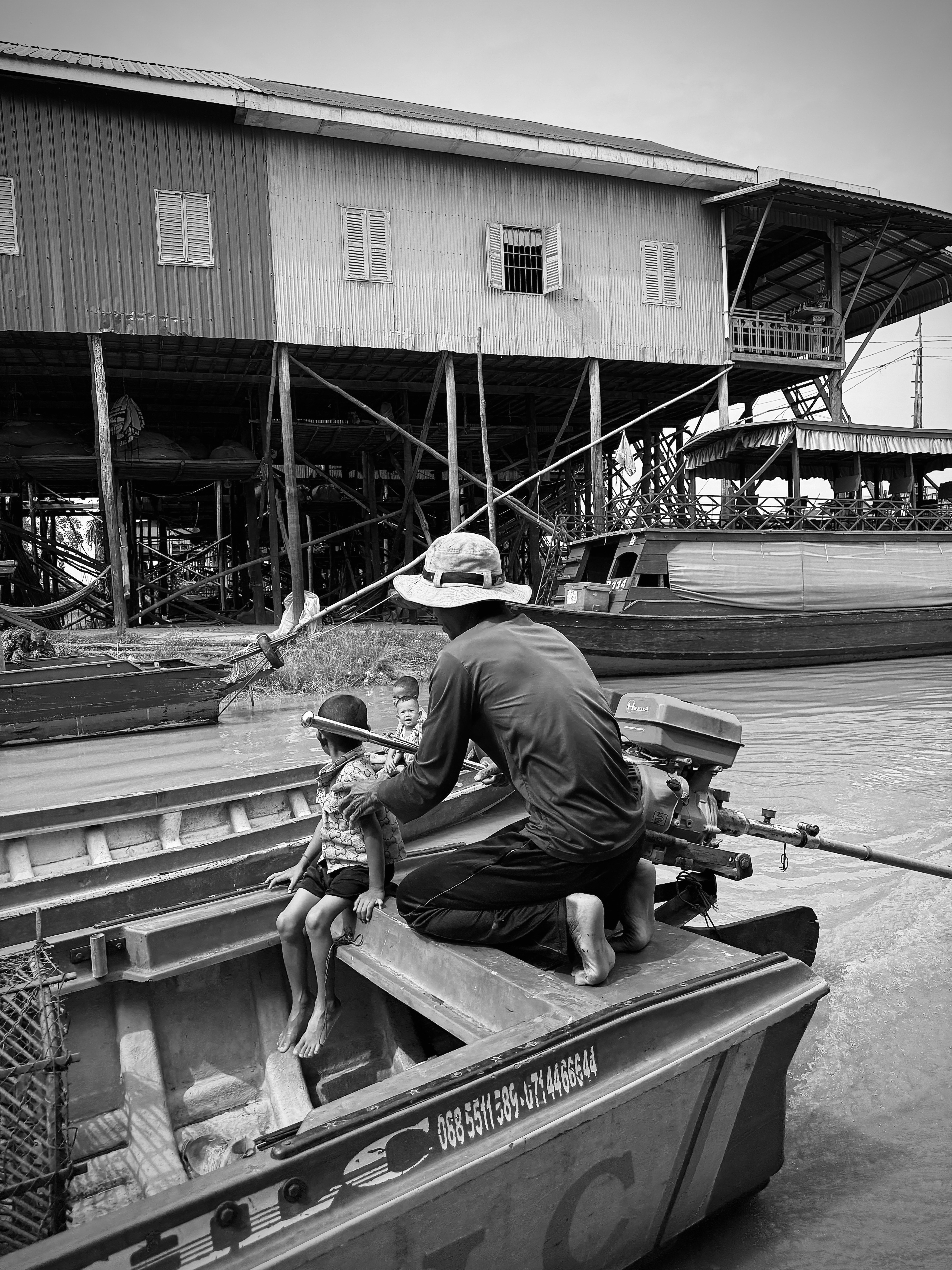 Man and child on a boat near stilt houses
