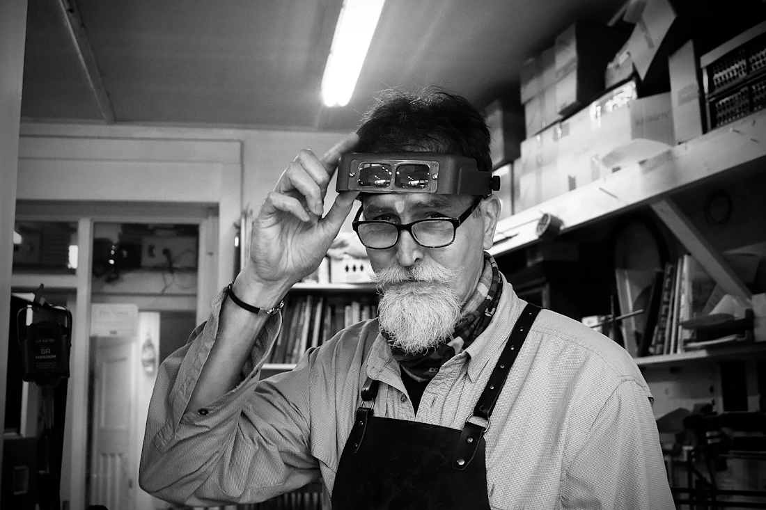 A jeweller working on a piece of jewellery at the bench