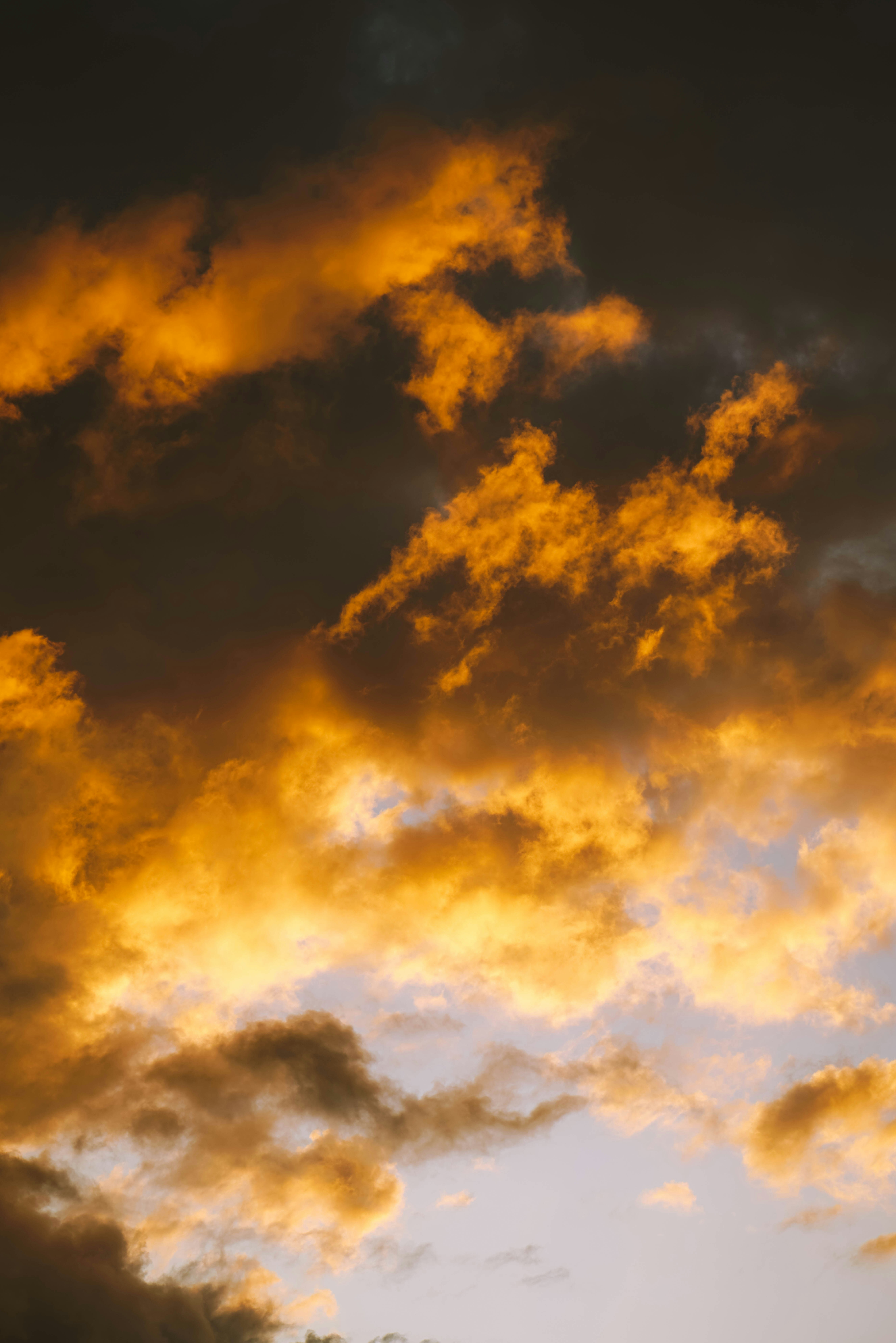 Nuages dorés spectaculaires au coucher du soleil avec ciel sombre.
