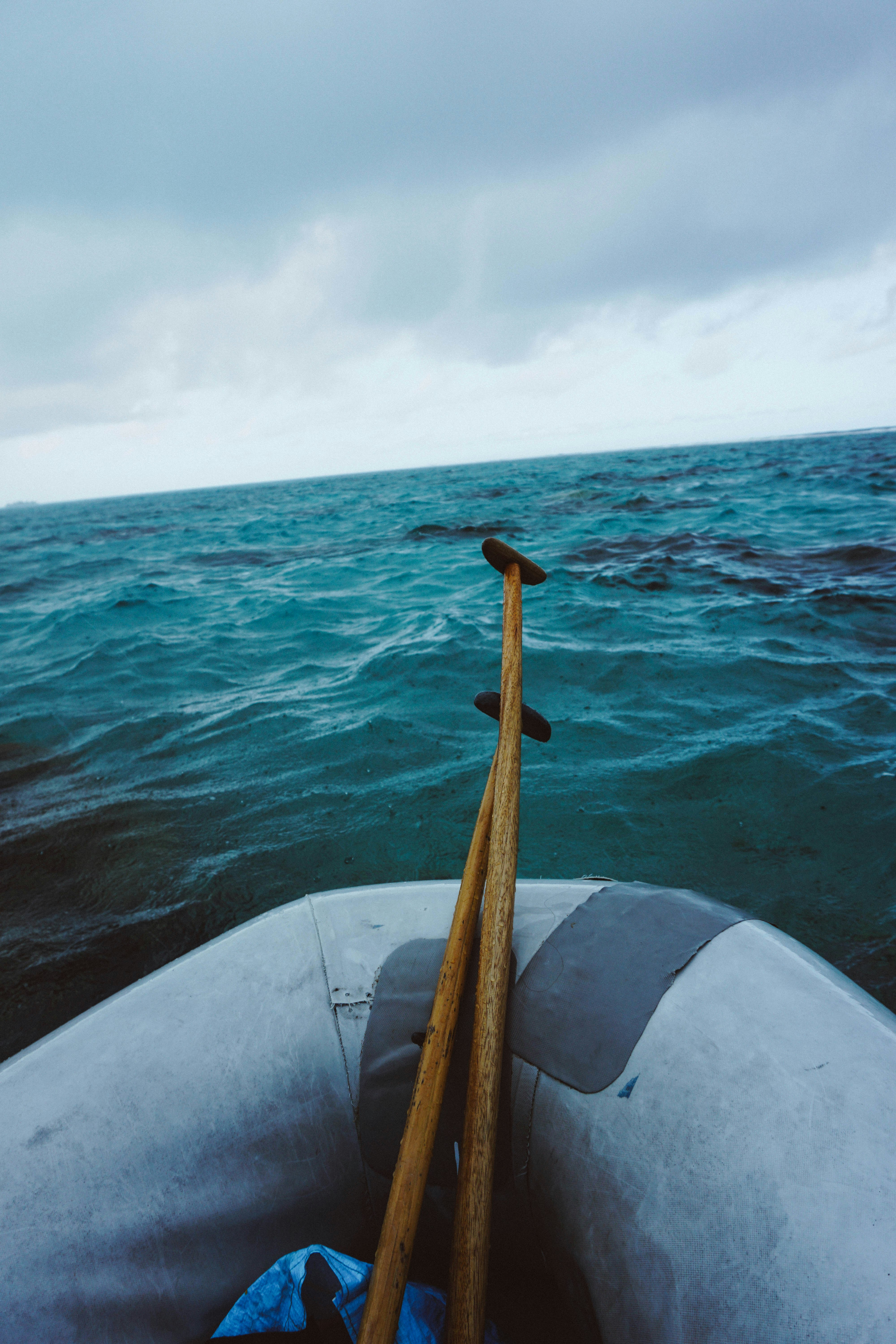 Deux rames reposent dans un bateau pneumatique sur l’océan.