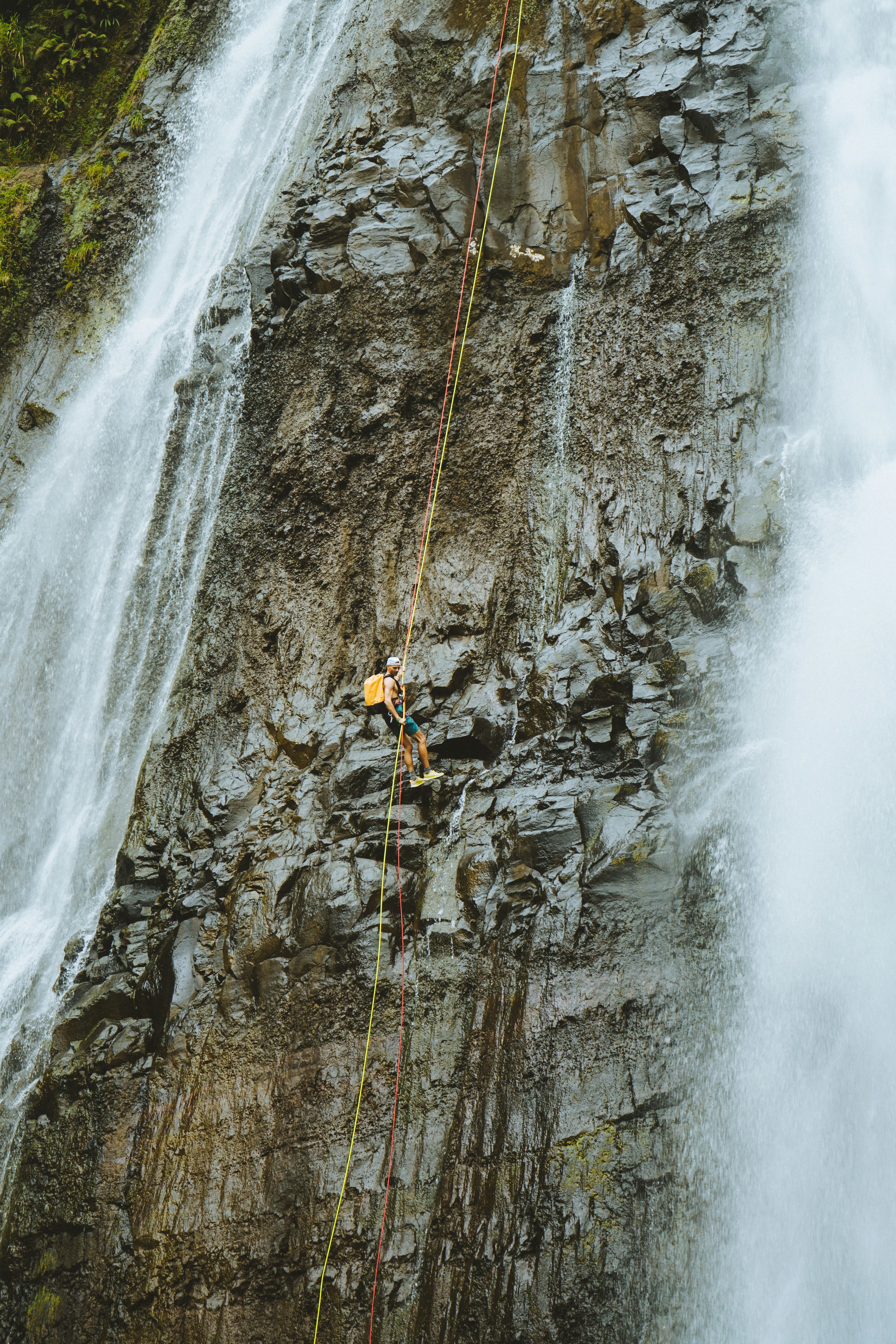 Personne descendant en rappel une cascade rocheuse
