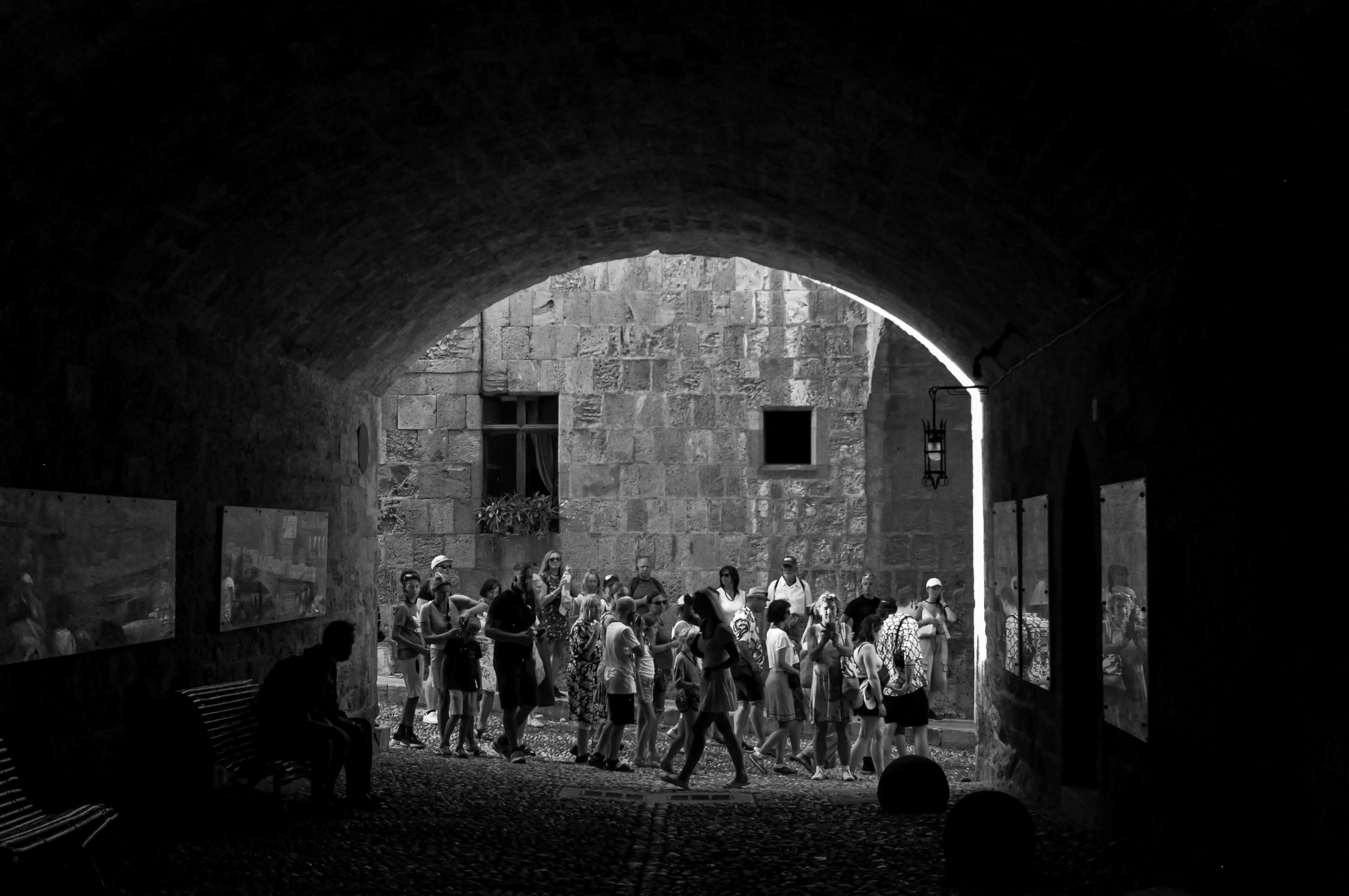 Group of people gathered in an arched walkway.