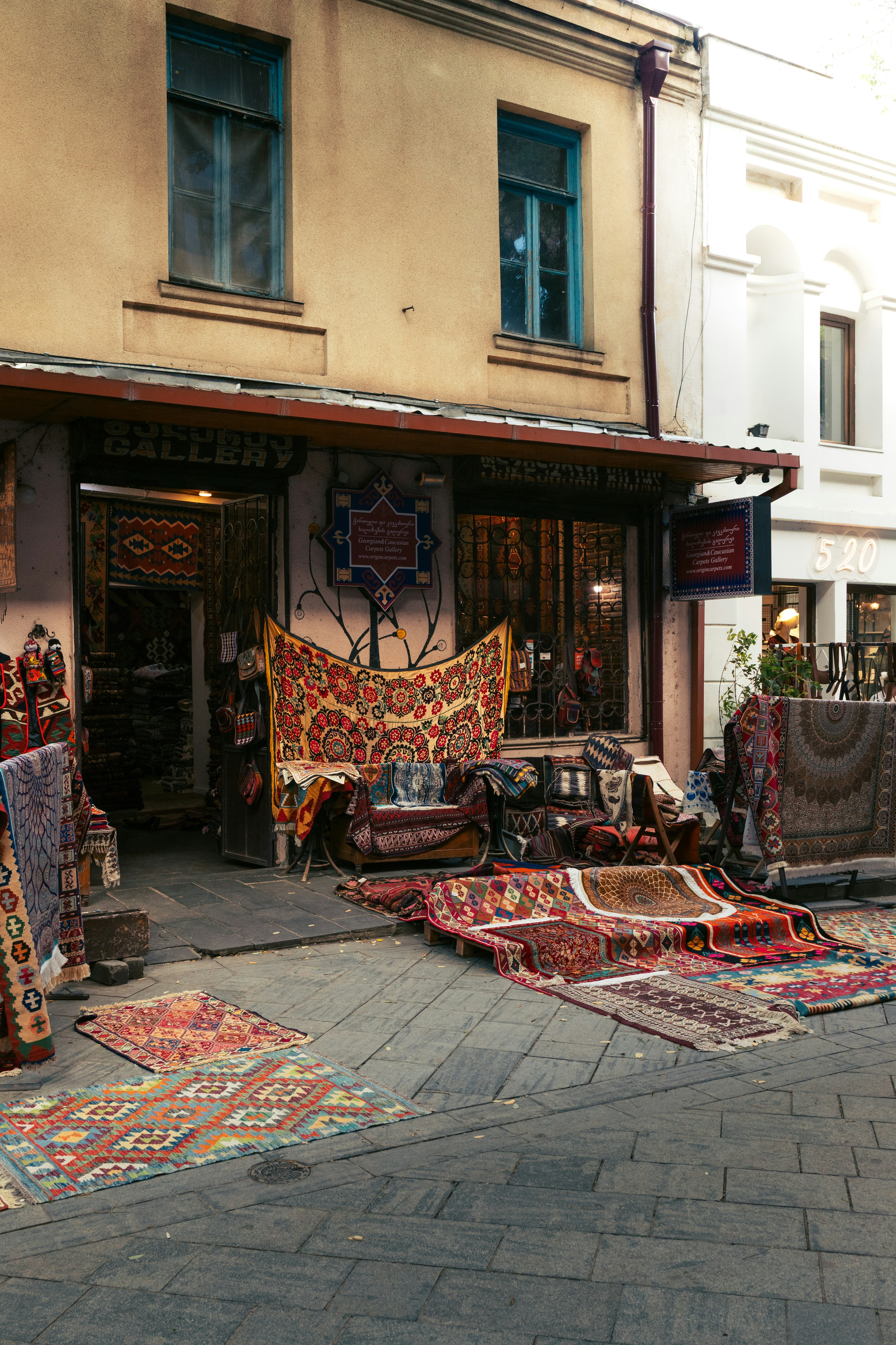 Rugs and carpets displayed outside a shop entrance.