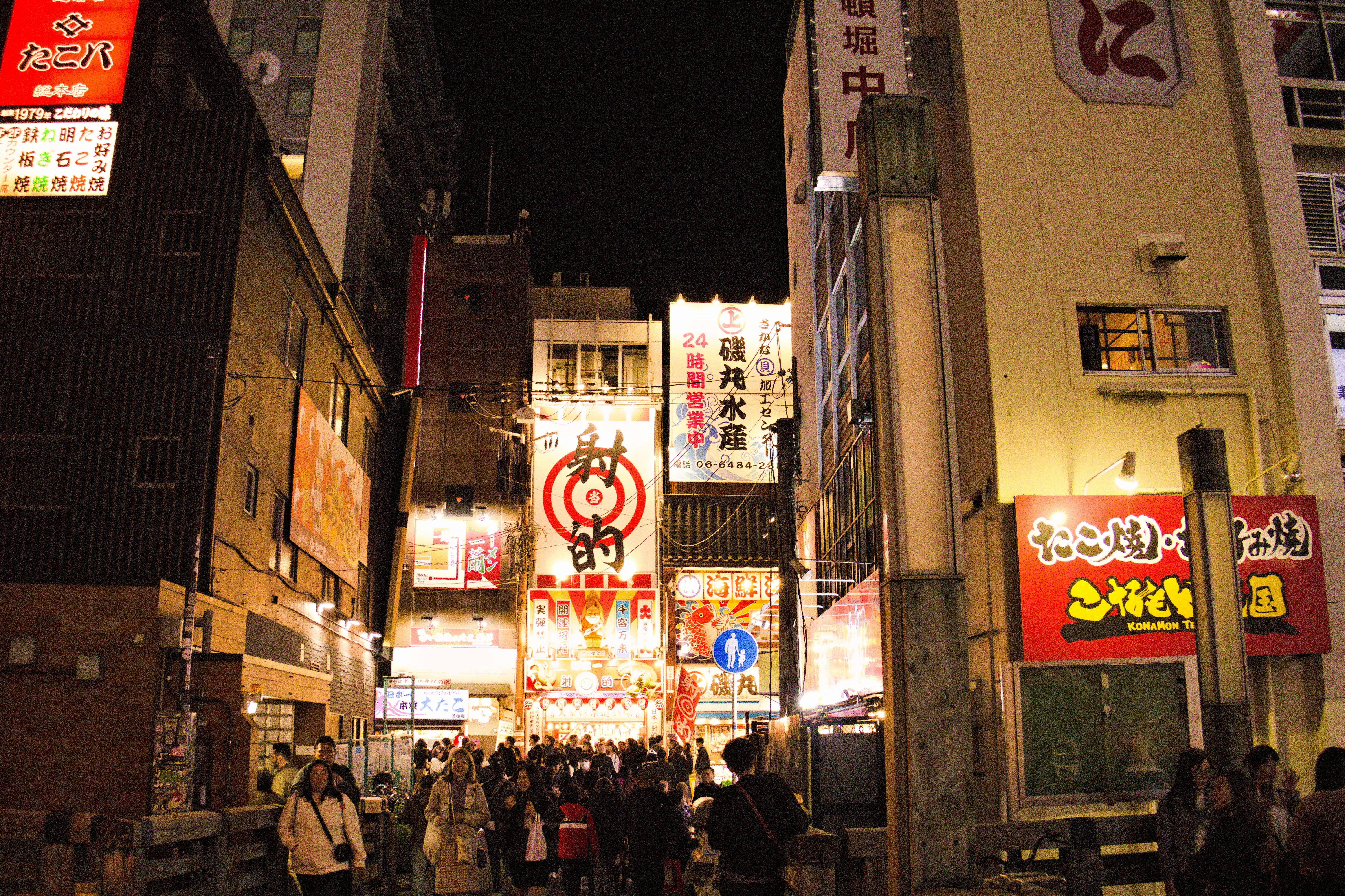 Busy street scene with illuminated signs at night.