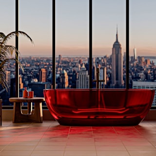 Modern red bathtub with city view at sunset