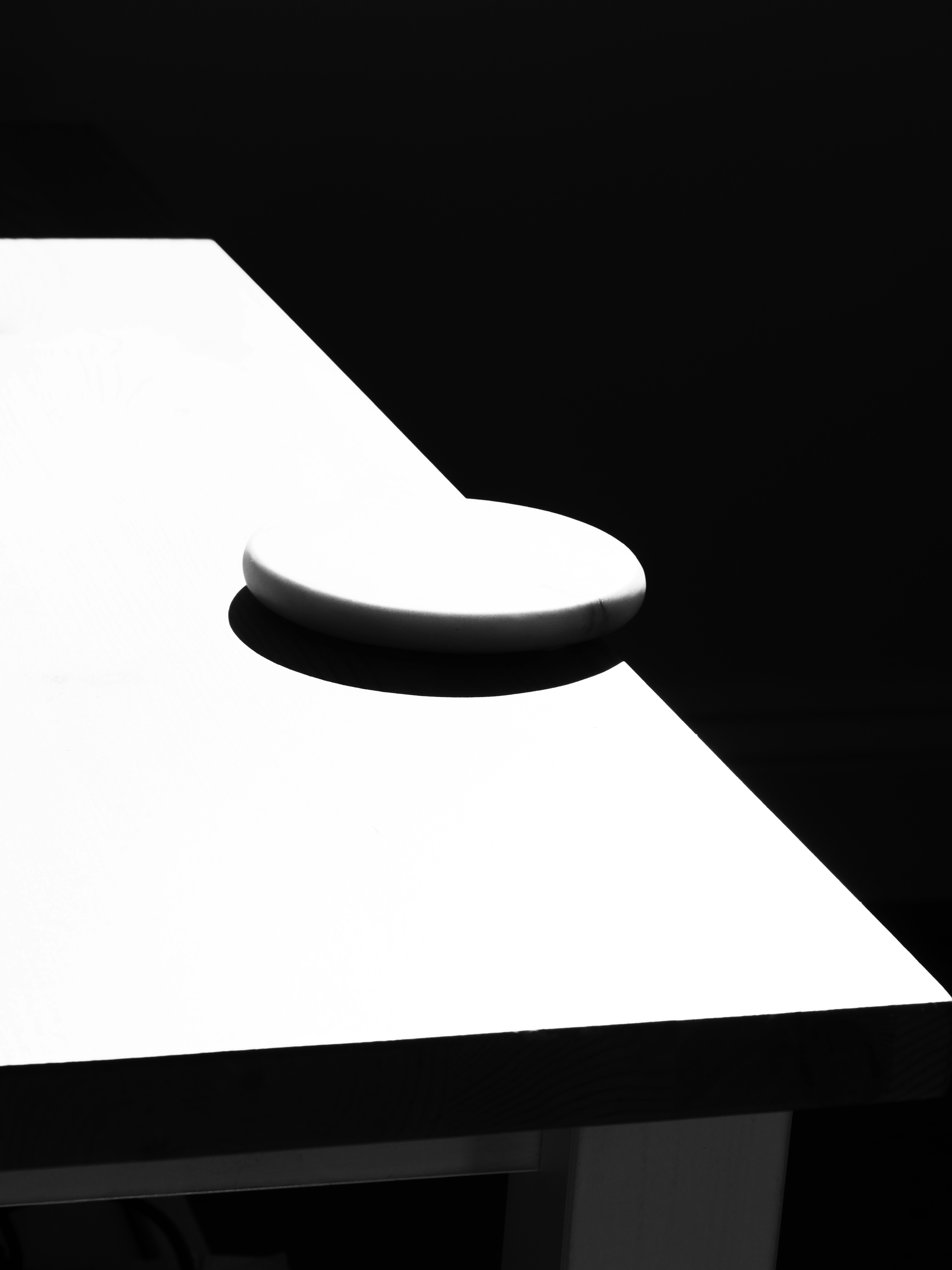 Ein einzelner Kieselstein auf weißer Fläche