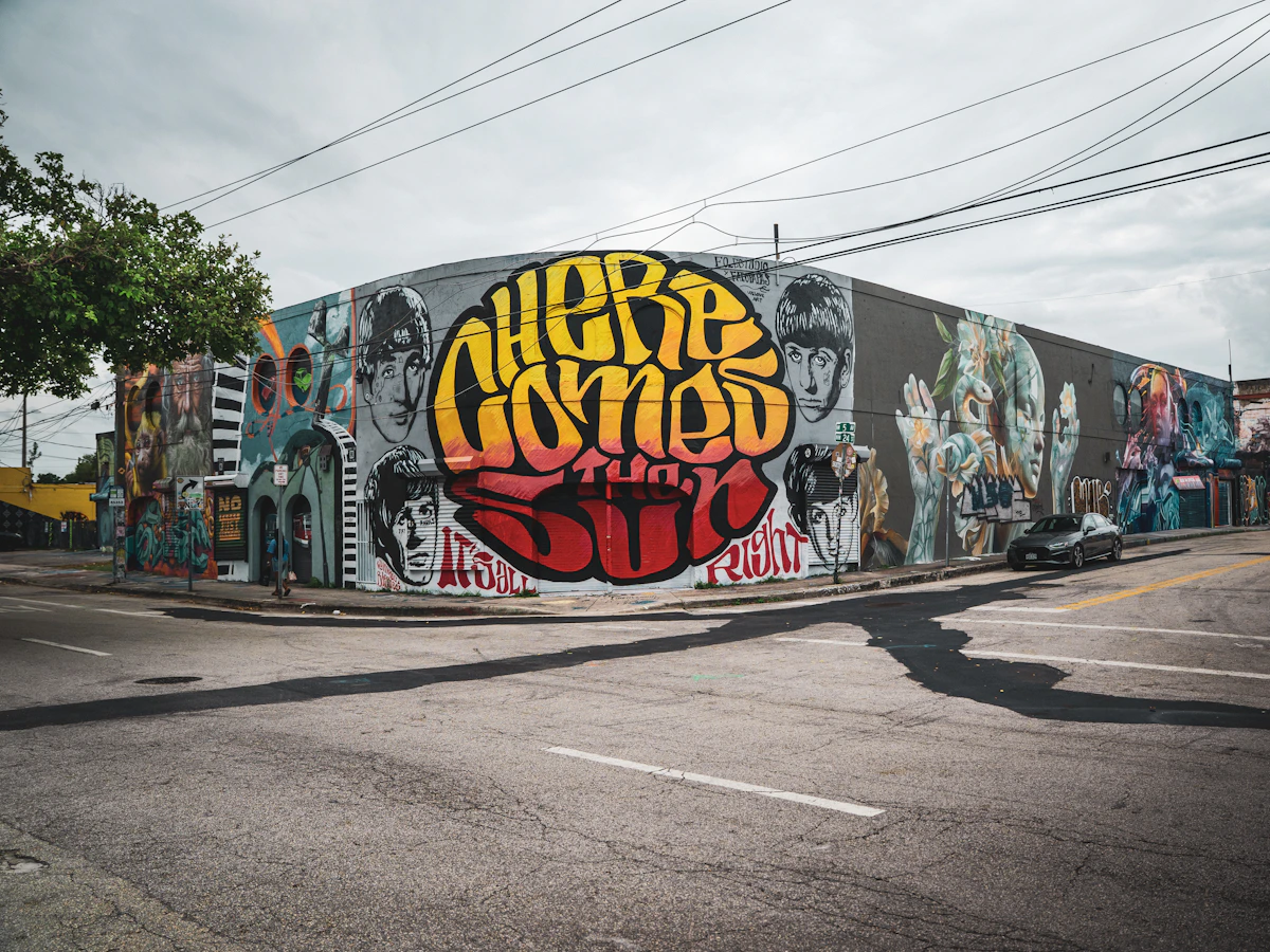 A low Wynwood building covered in large colourful street-art murals