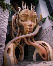 Abstract mosaic sculpture of a serene face with flowing elements.