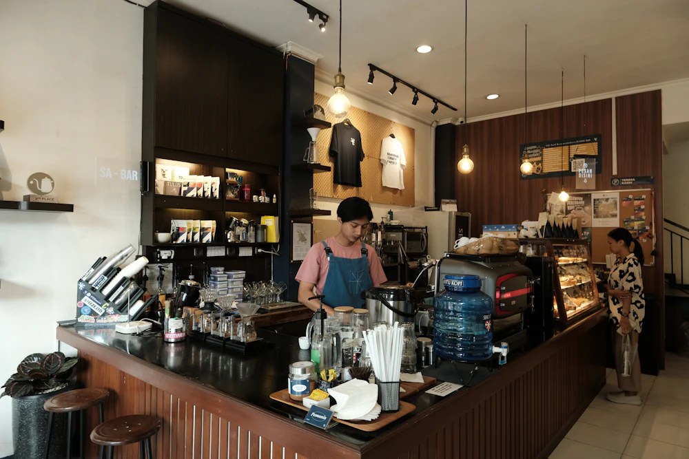 A barista preparing drinks behind a cafe counter