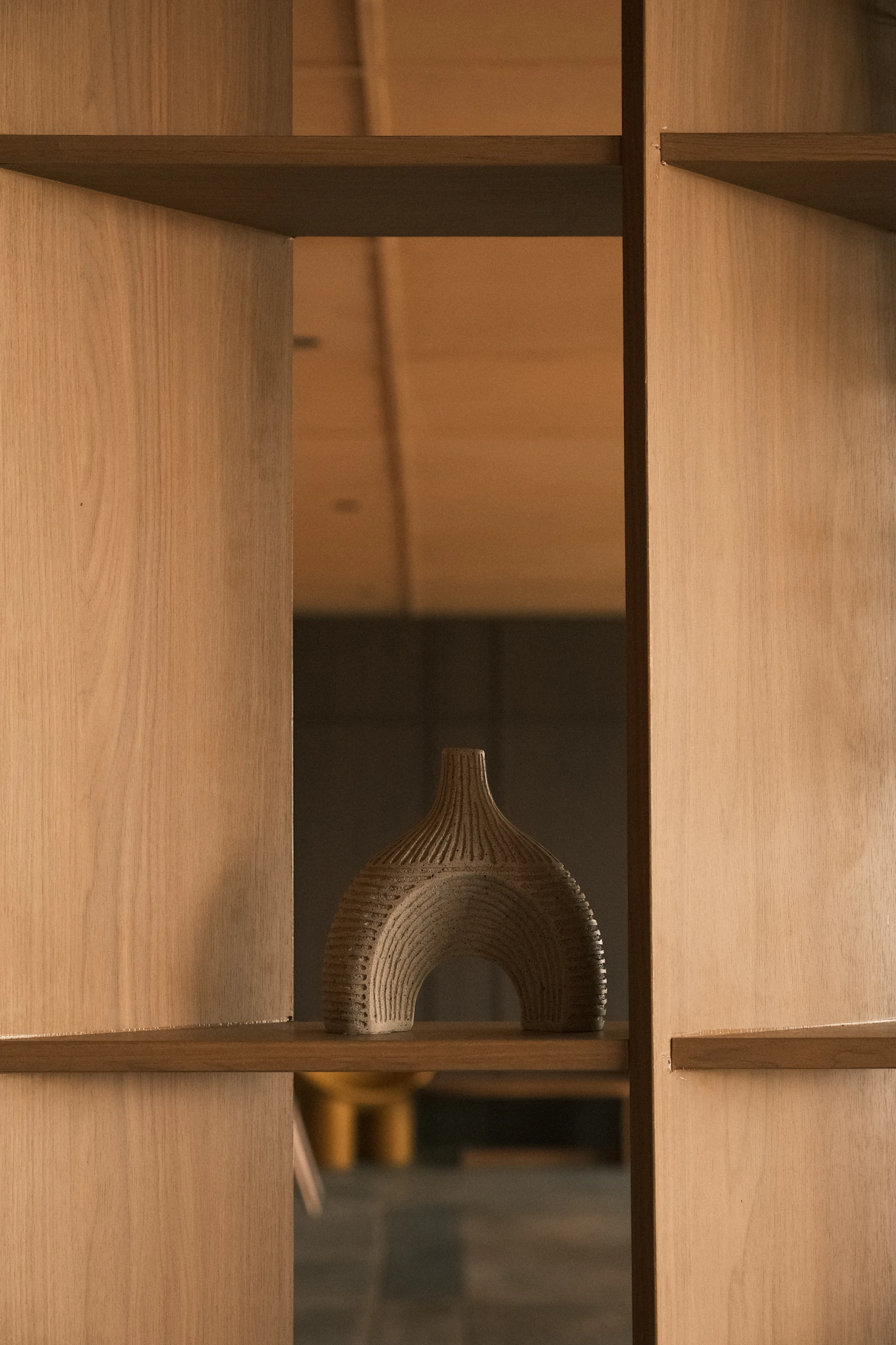 Minimal ceramic vase arranged on a natural wooden shelf in a contemporary home interior